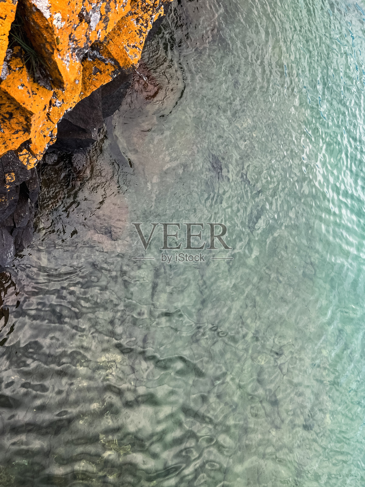 站在岩石峭壁上俯瞰苏必利尔湖蓝绿色的湖水照片摄影图片