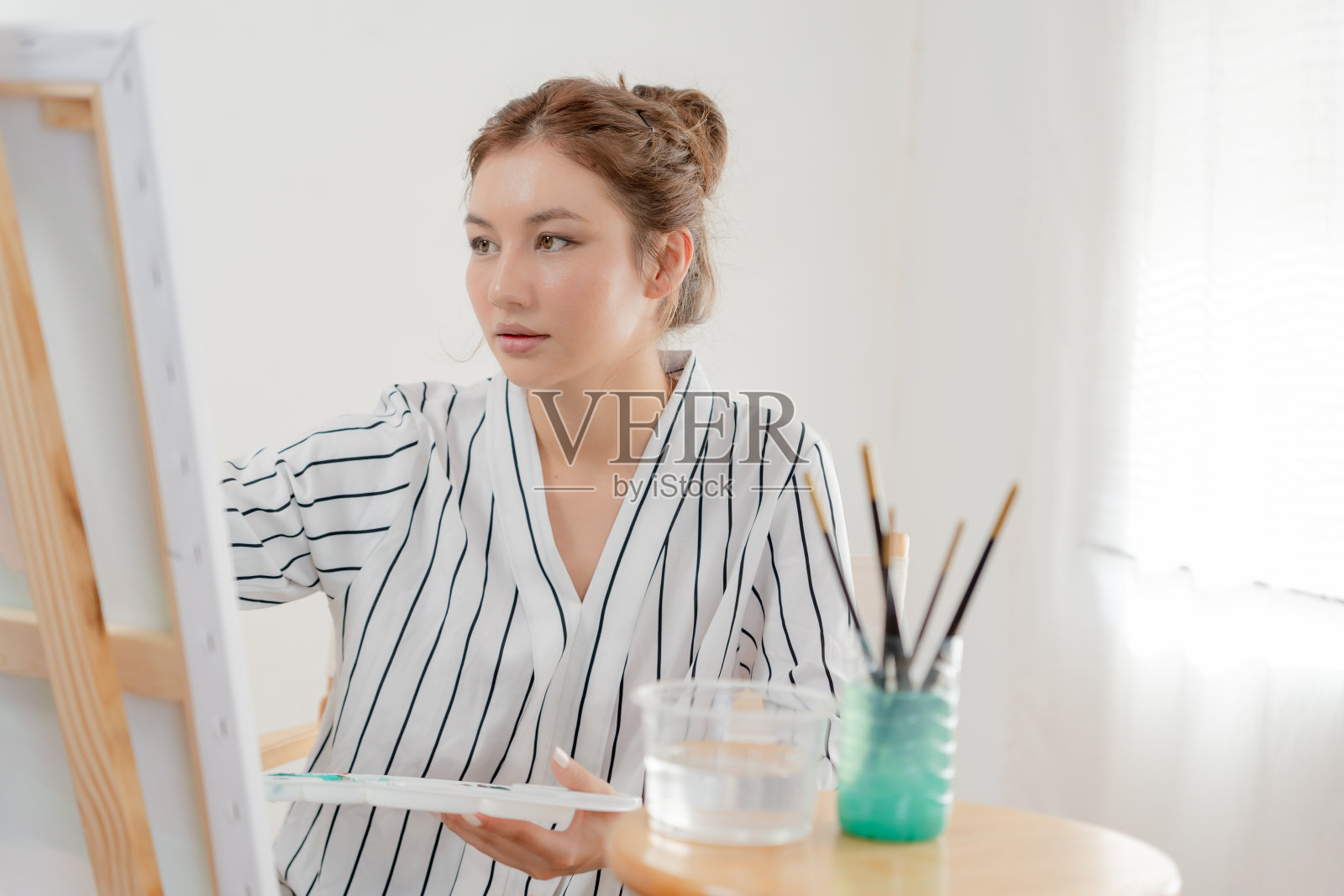 美丽的女性爱好艺术家和使用画笔在抽象艺术创作杰作。画家在工作室用水彩或油彩作画。享受绘画作为爱好，娱乐，灵感照片摄影图片