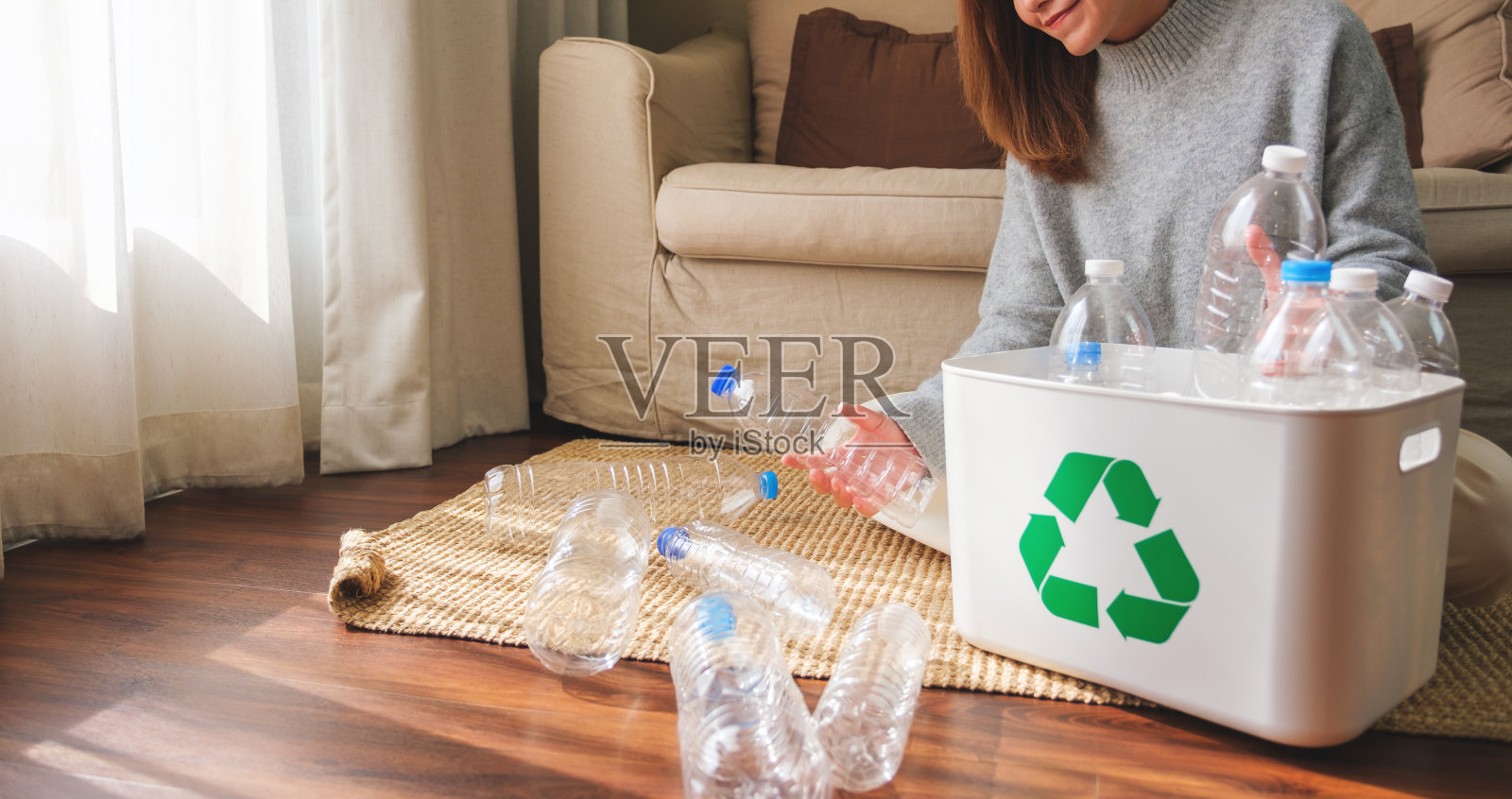 特写图像的妇女收集和分离可回收的垃圾塑料瓶在家里的垃圾桶照片摄影图片