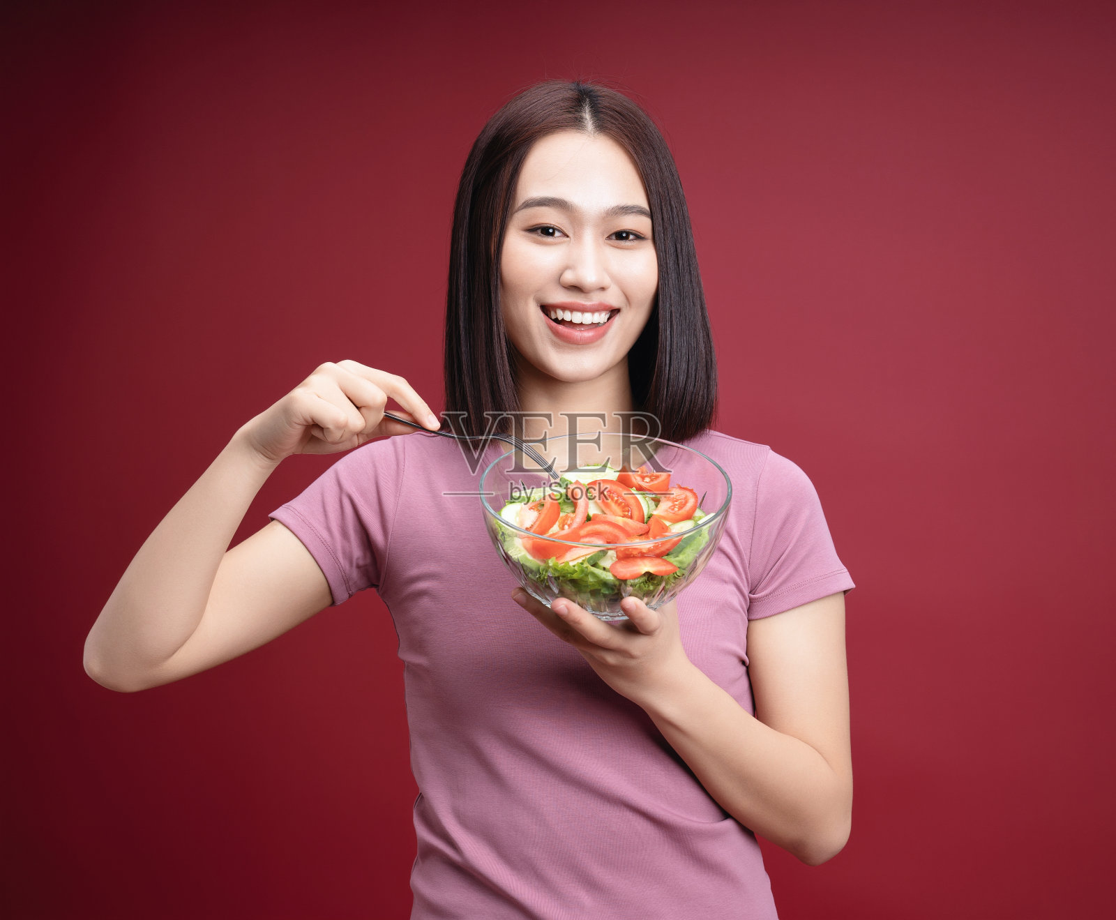 年轻的亚洲女子吃沙拉的背景照片摄影图片