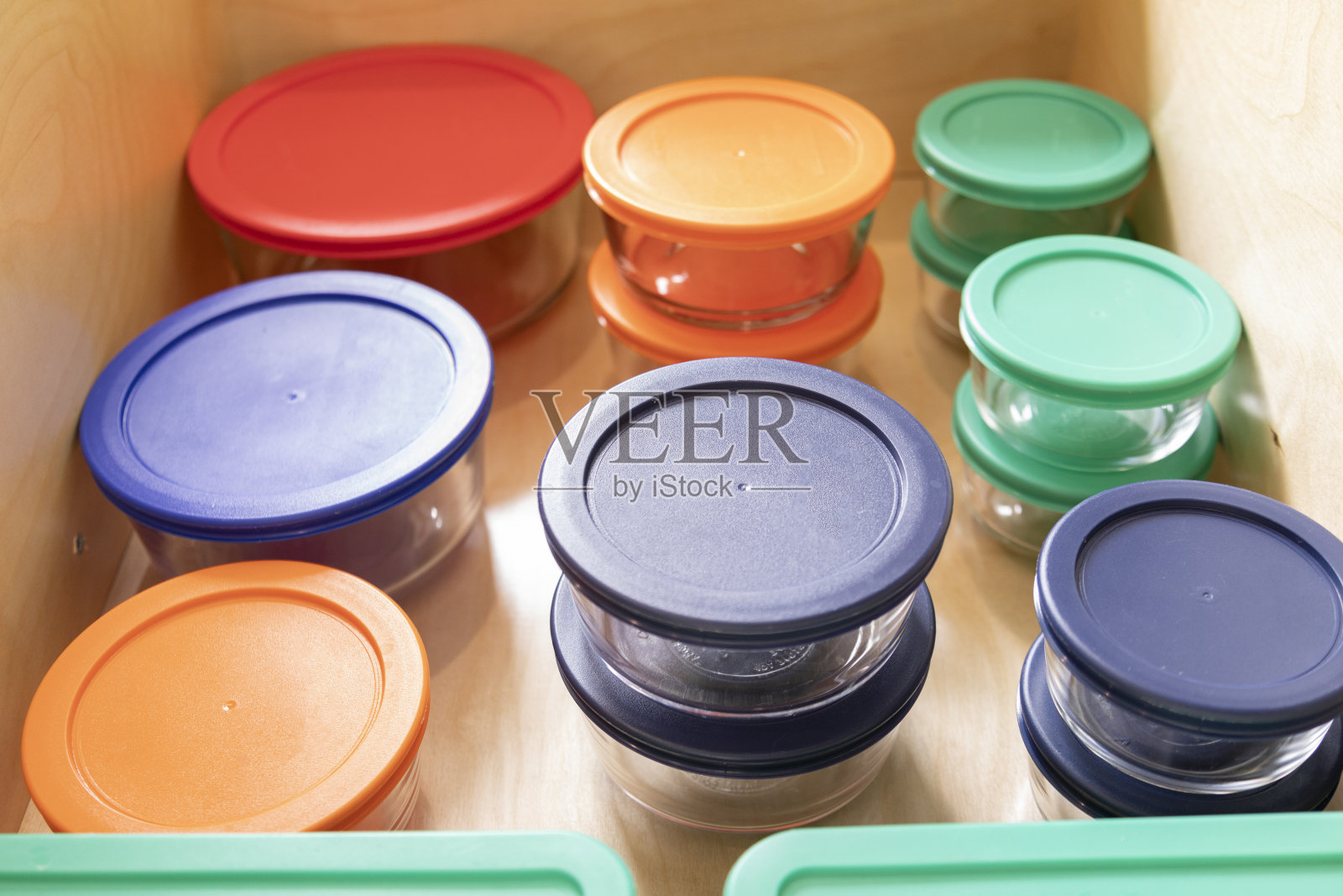 厨房抽屉里有彩色塑料盖子的玻璃容器照片摄影图片