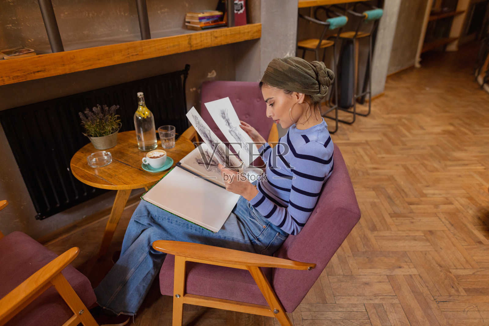 快乐的女艺术家看着她的素描照片摄影图片