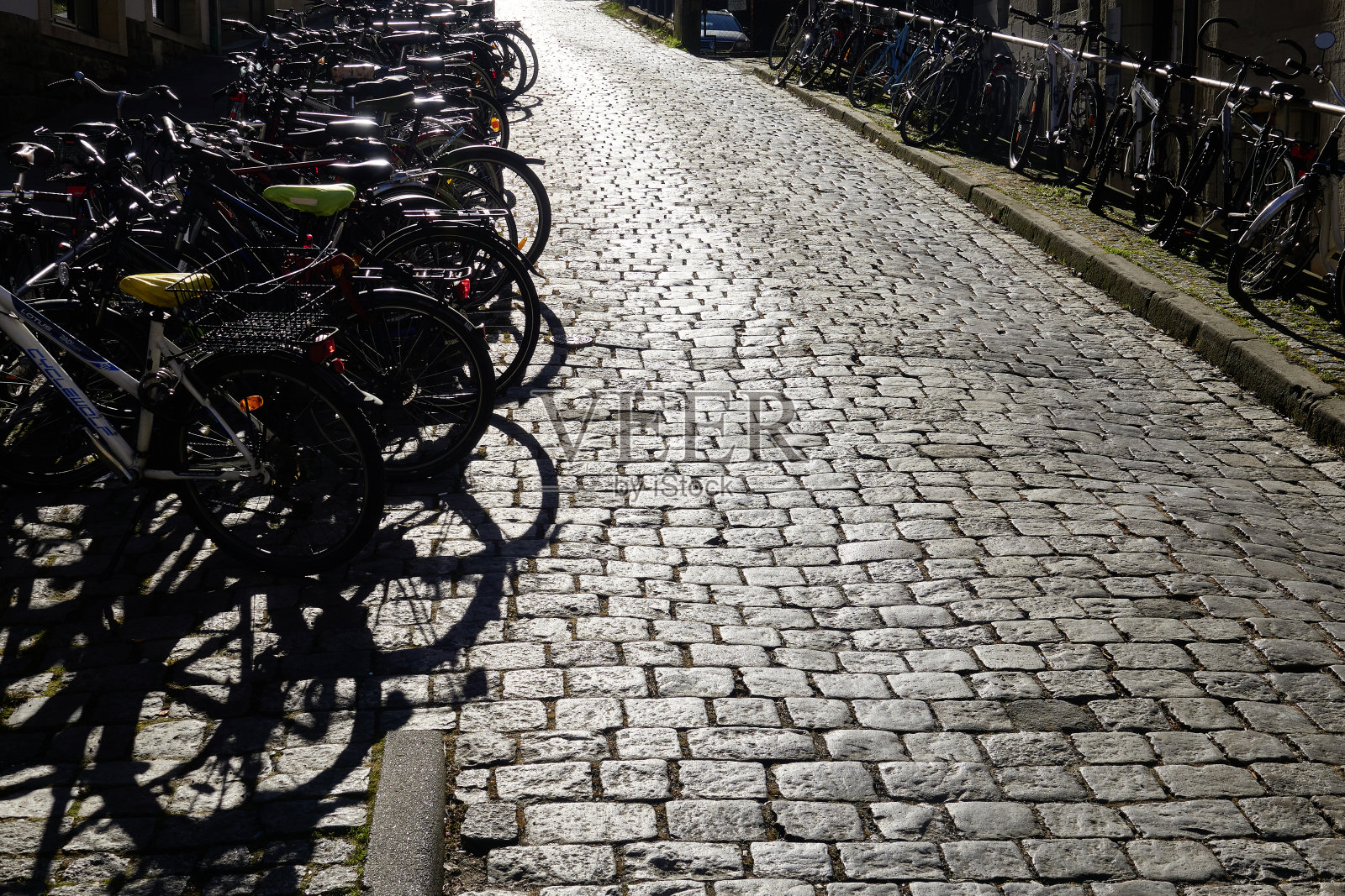 一排自行车停在鹅卵石街道上照片摄影图片
