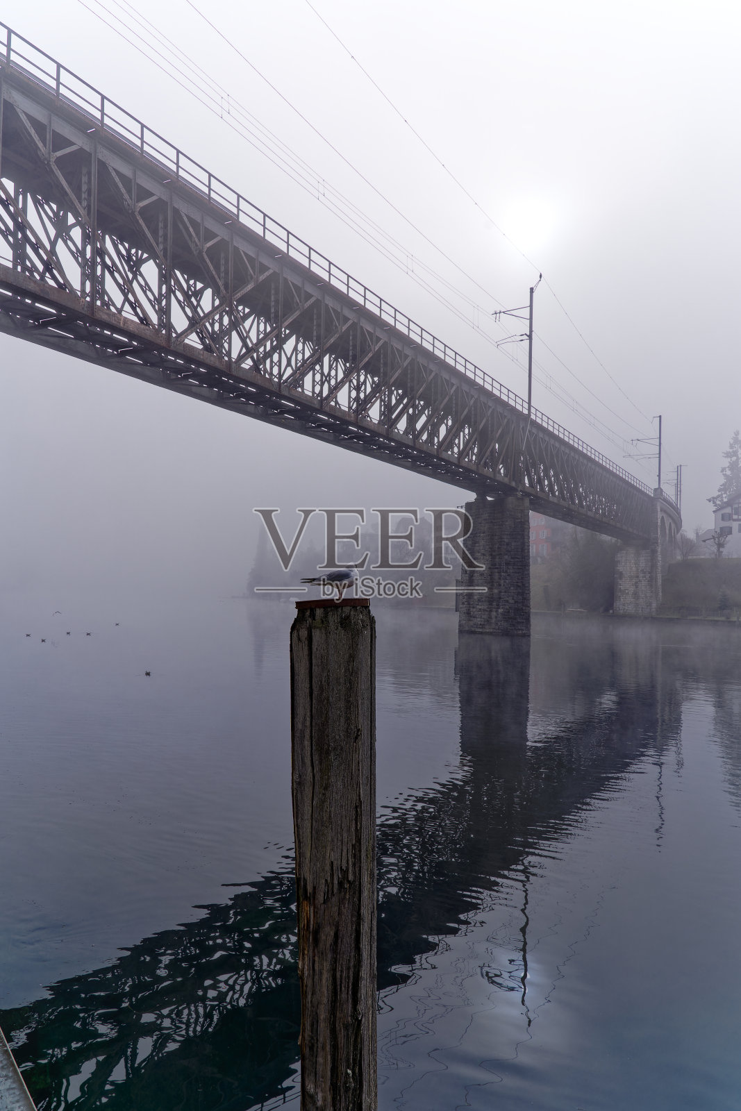 河流与城市景观和铁路高架桥与灰色天空背景在瑞士小镇。照片摄影图片