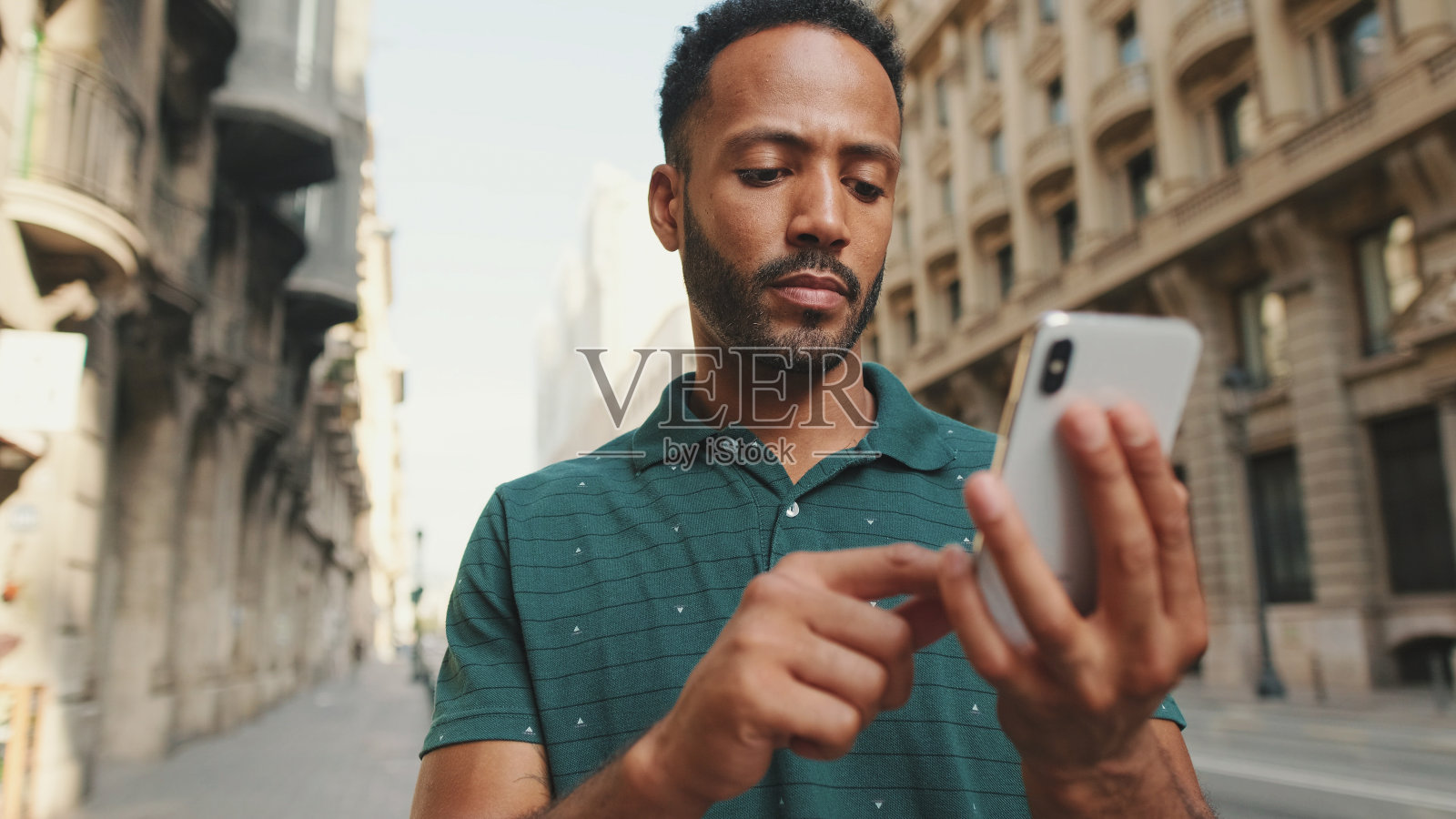 一个年轻人站在路边用手机的特写镜头照片摄影图片