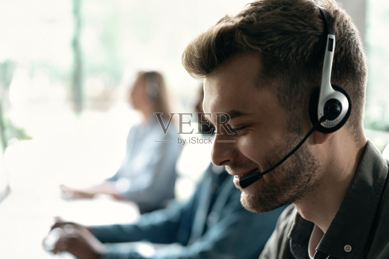 快乐的年轻男性客户支持主管在办公室工作照片摄影图片