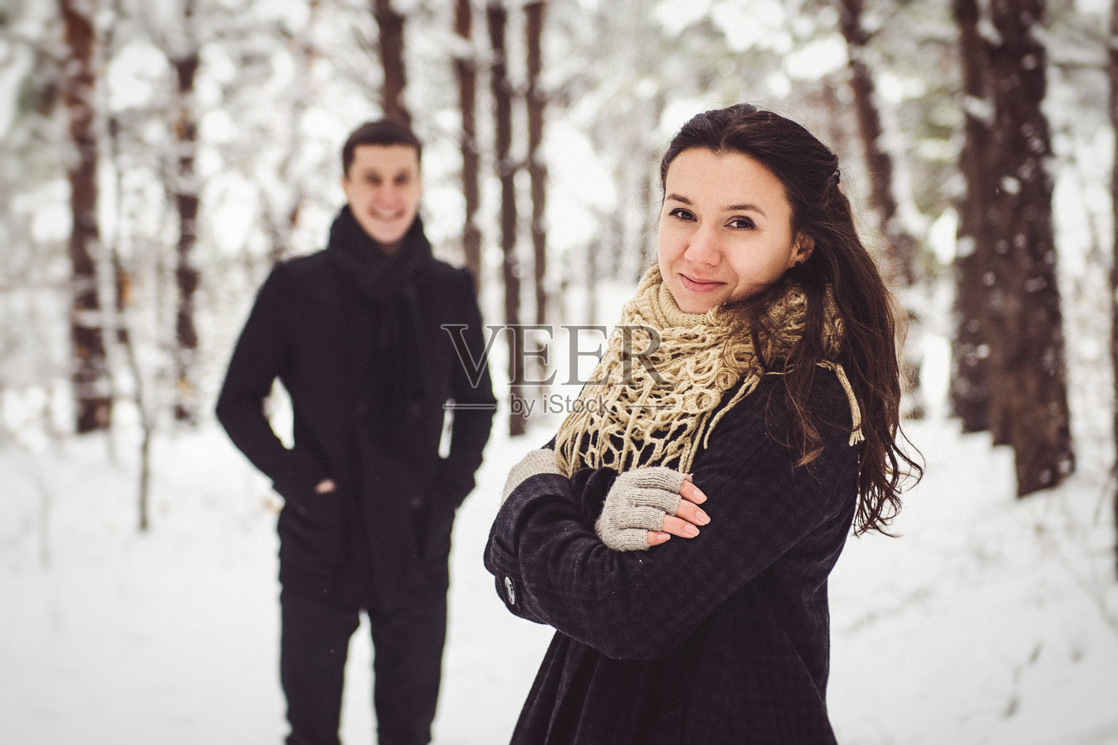 一个男孩和一个女孩穿着暖和的衣服和围巾在雪天散步照片摄影图片