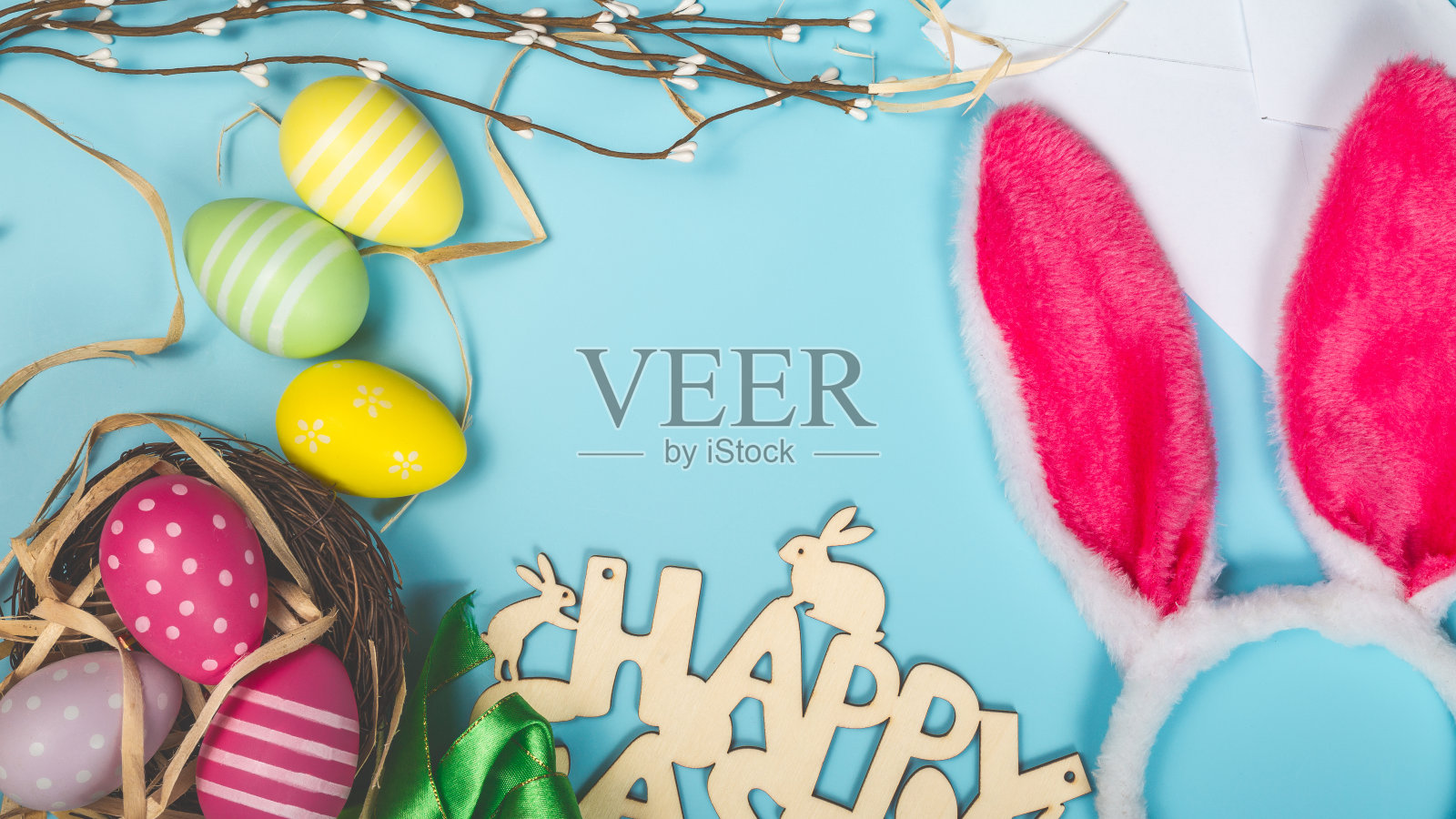 祝贺明信片与复活节彩蛋的蓝色背景和兔子耳朵和地方的文字顶部视图照片摄影图片