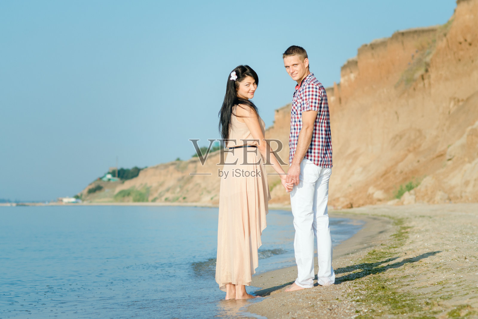 一个男孩和一个女孩在海边散步照片摄影图片