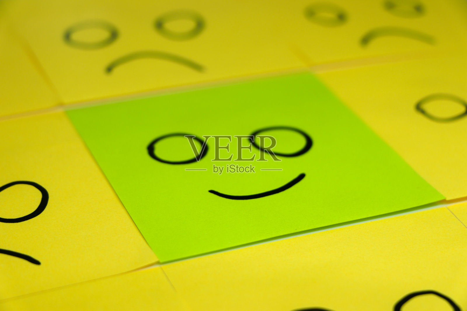 不快乐和快乐的概念。绿色便利贴的背景。不快乐的便利贴是快乐便利贴中的一种。照片摄影图片