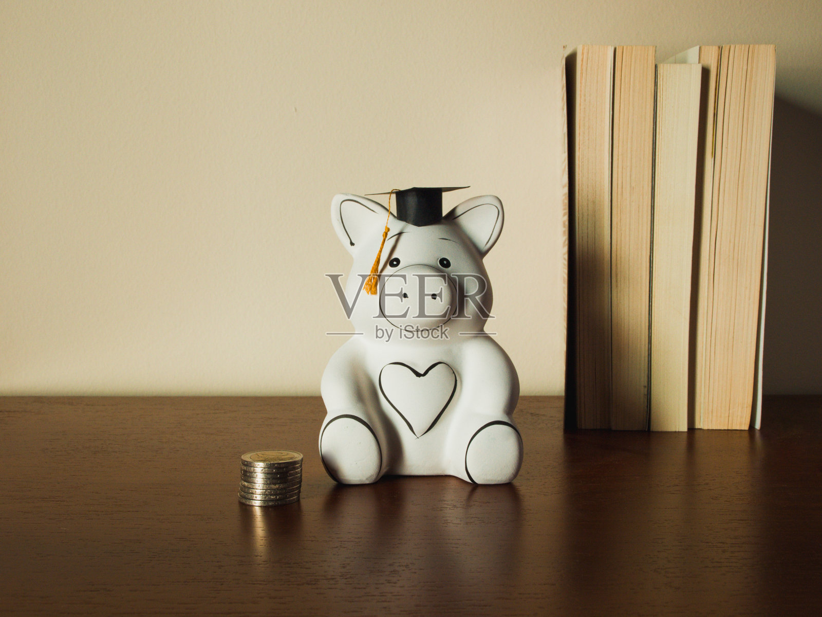 木制柜子上的白色储蓄罐和毕业帽照片摄影图片