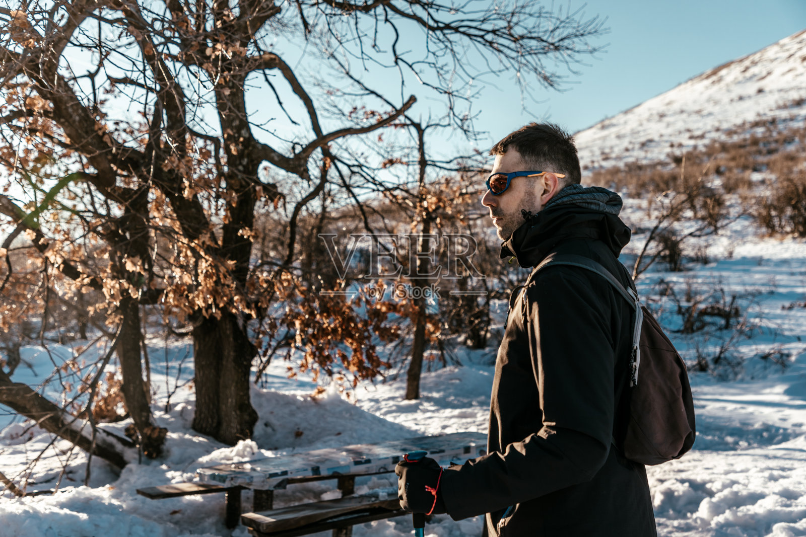 男登山者戴墨镜，雪地特写照片摄影图片