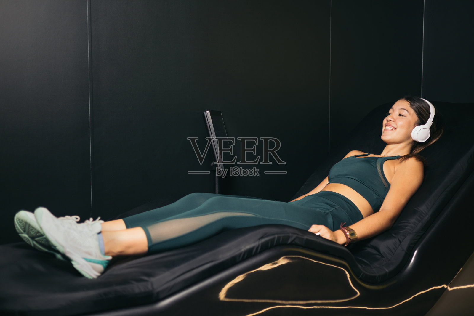 亚洲女孩躺在电动水床上进行色彩疗法休息照片摄影图片