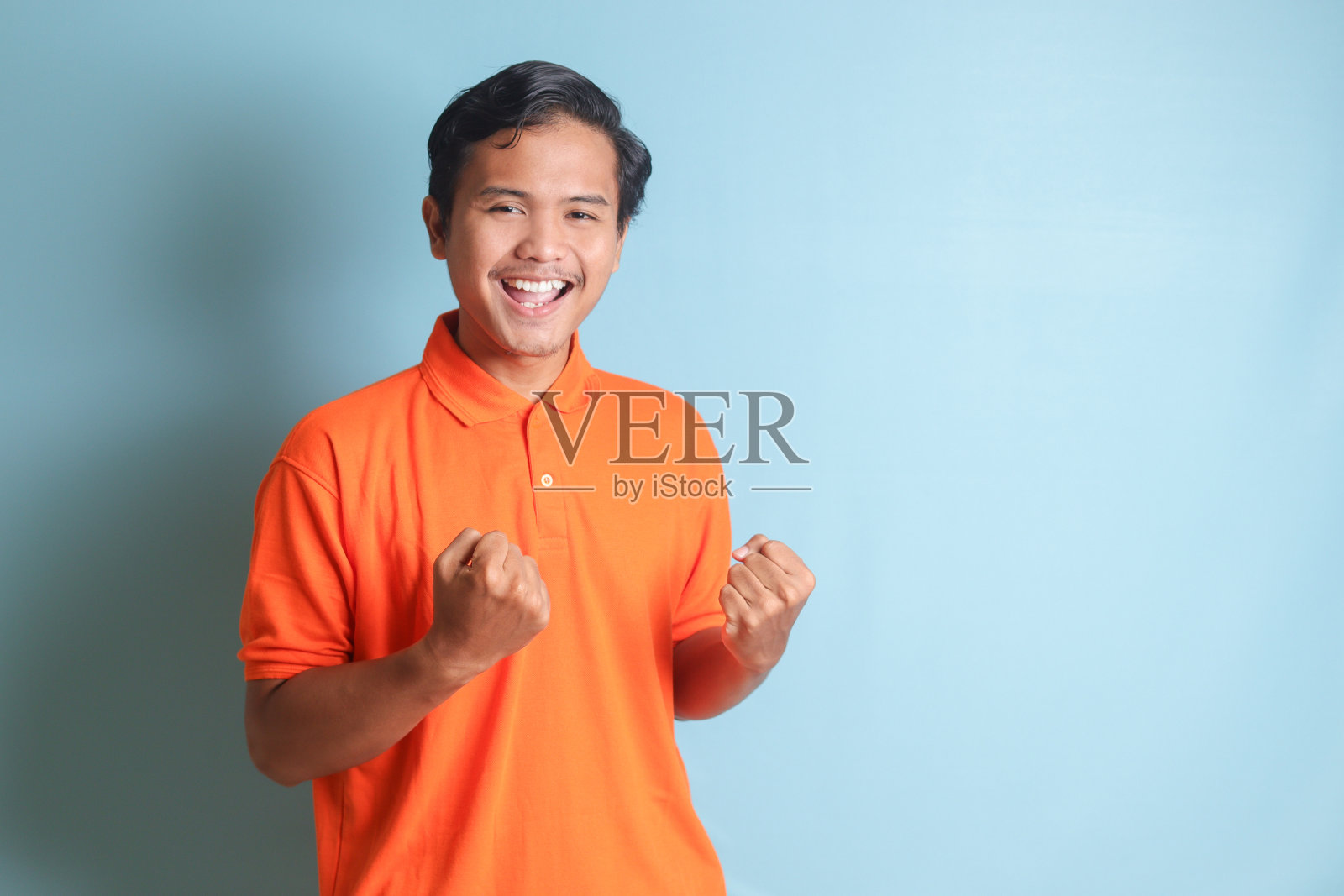 亚洲男子举起拳头，庆祝成功照片摄影图片