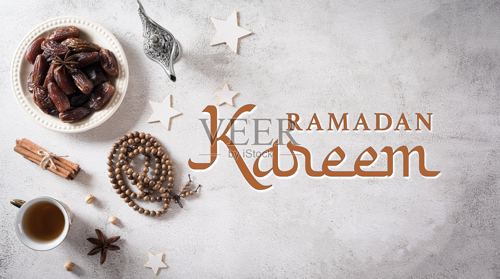 斋月食品和饮料概念。斋月阿拉伯灯，木念珠，茶，和枣水果在石头背景。照片摄影图片