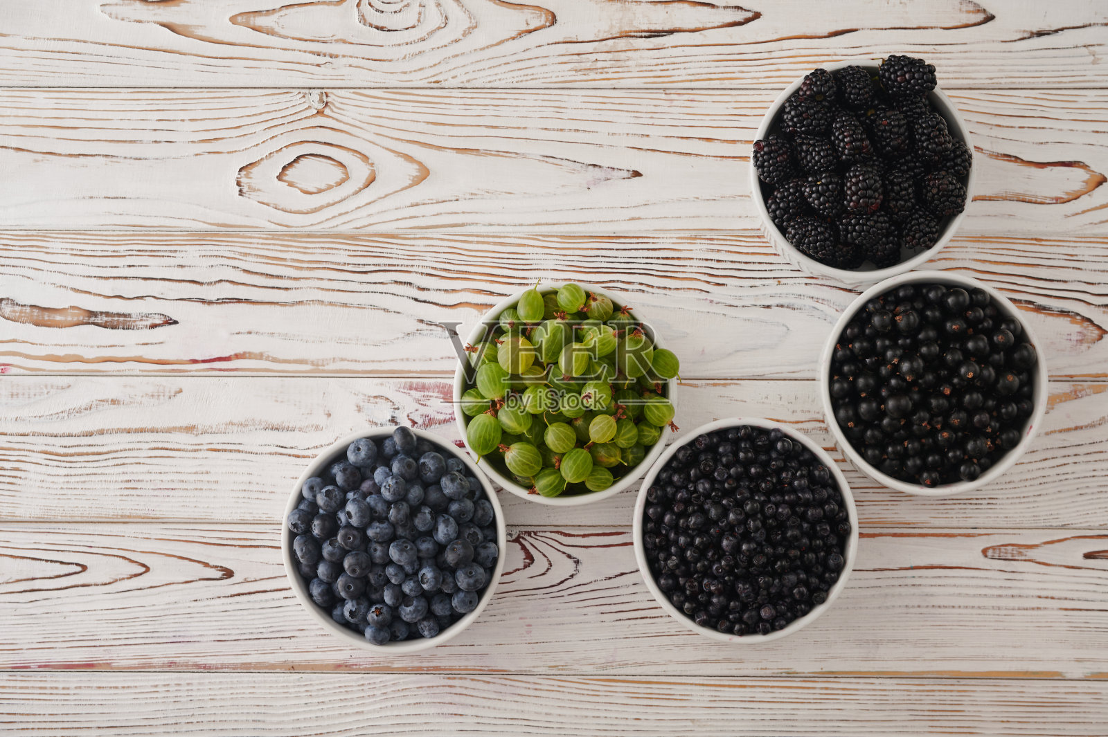 六碗新鲜浆果，木质背景。水果浆果背景。照片摄影图片