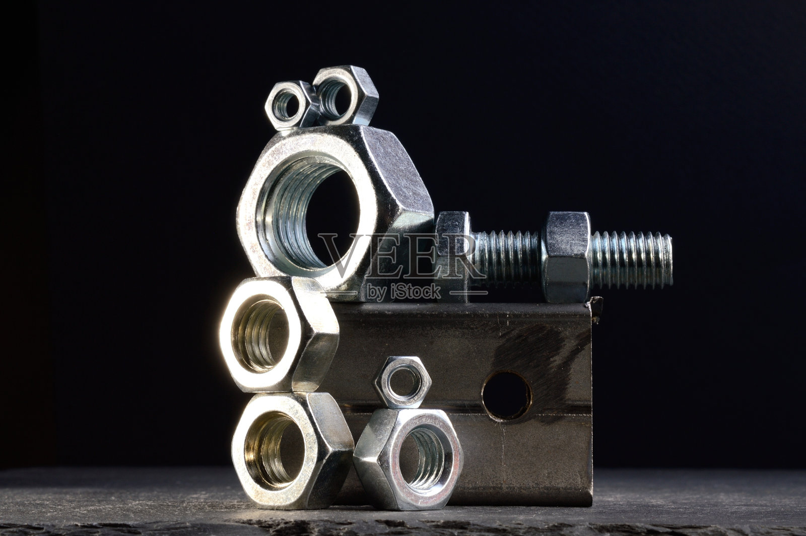 组成的螺母，螺栓和金属碎片布局在一个黑暗的背景。照片摄影图片