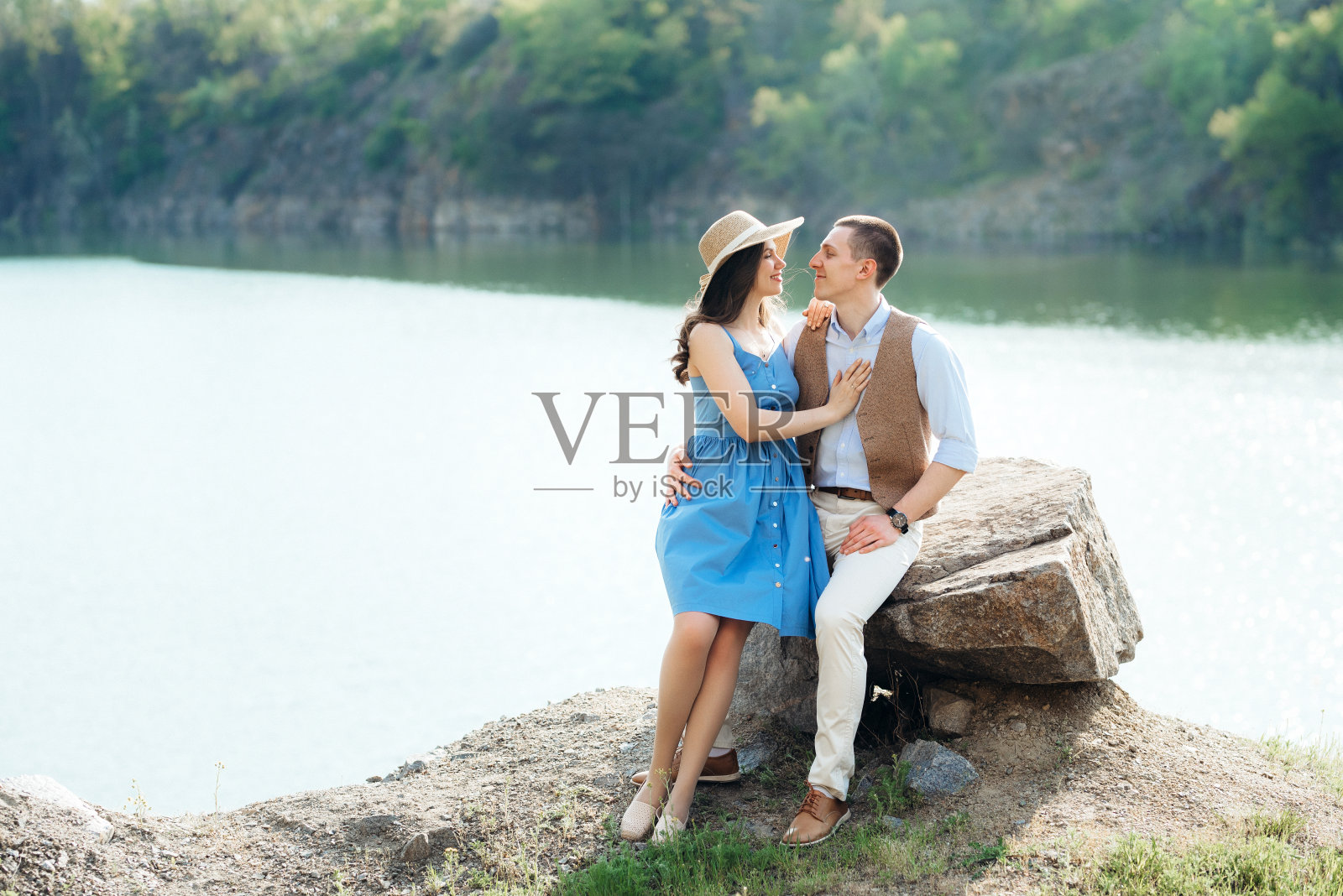 一对年轻夫妇，一个男孩和一个女孩走在山湖附近照片摄影图片