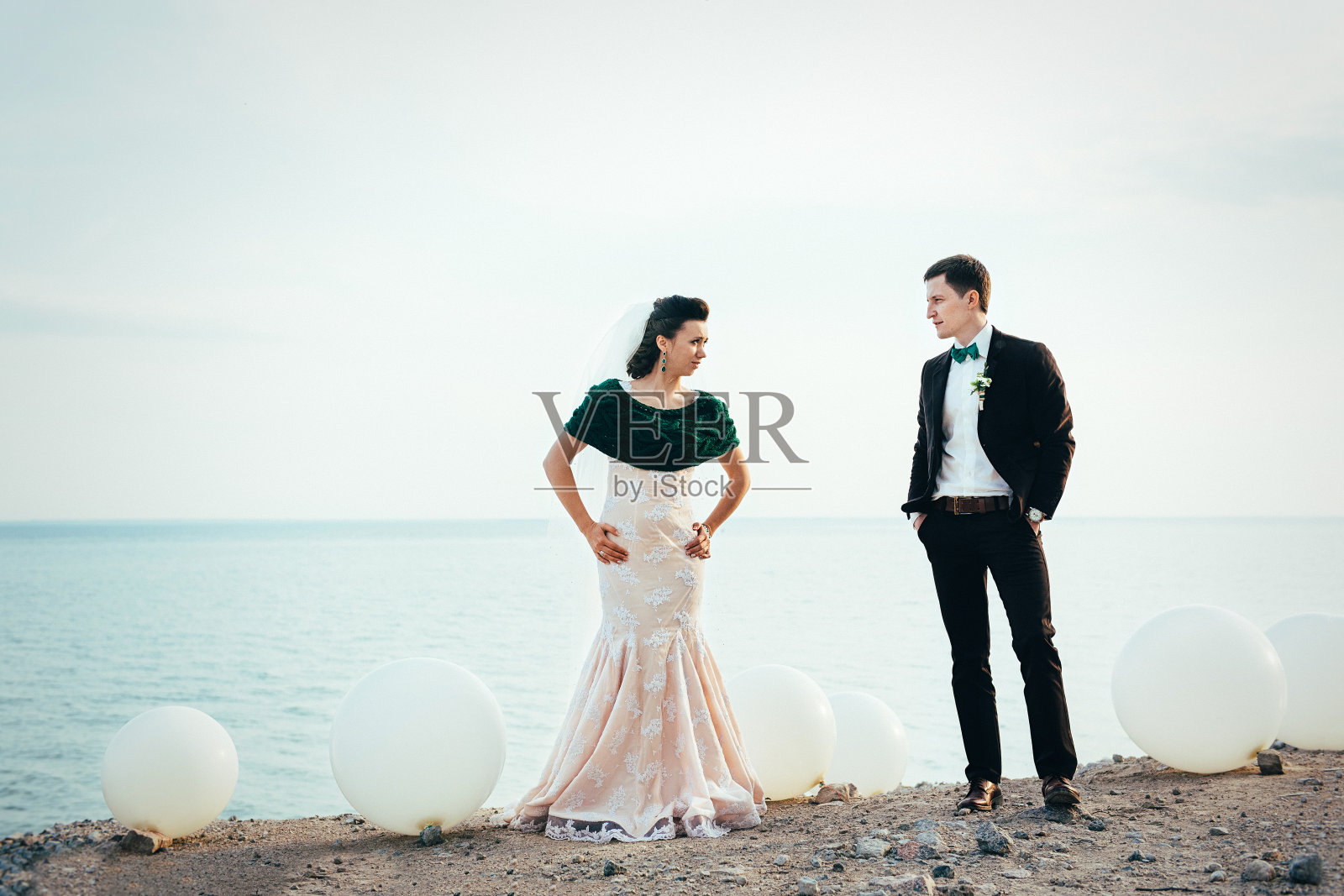 新郎穿棕色西装，新娘穿象牙色裙子照片摄影图片