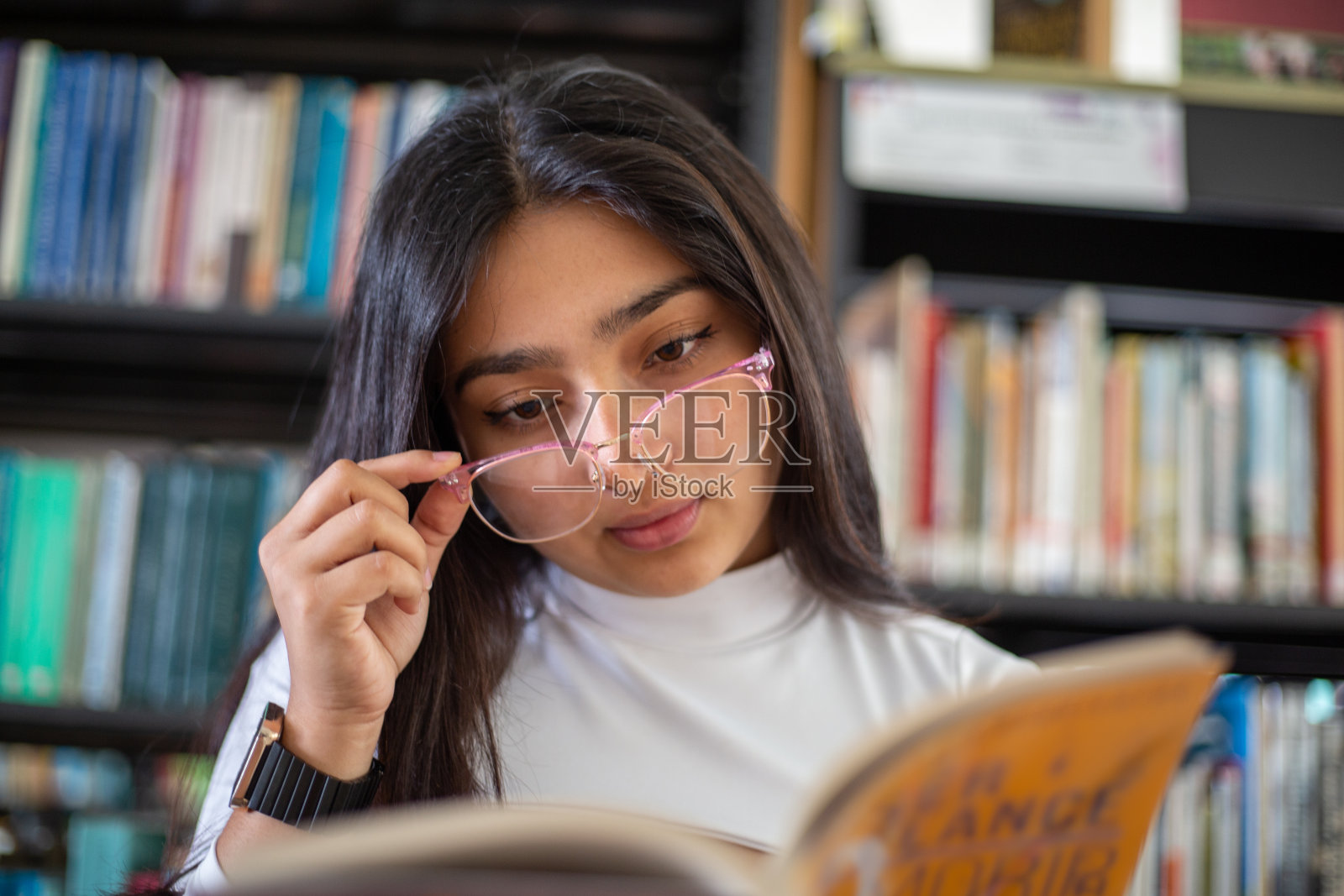 女孩在图书馆做作业照片摄影图片
