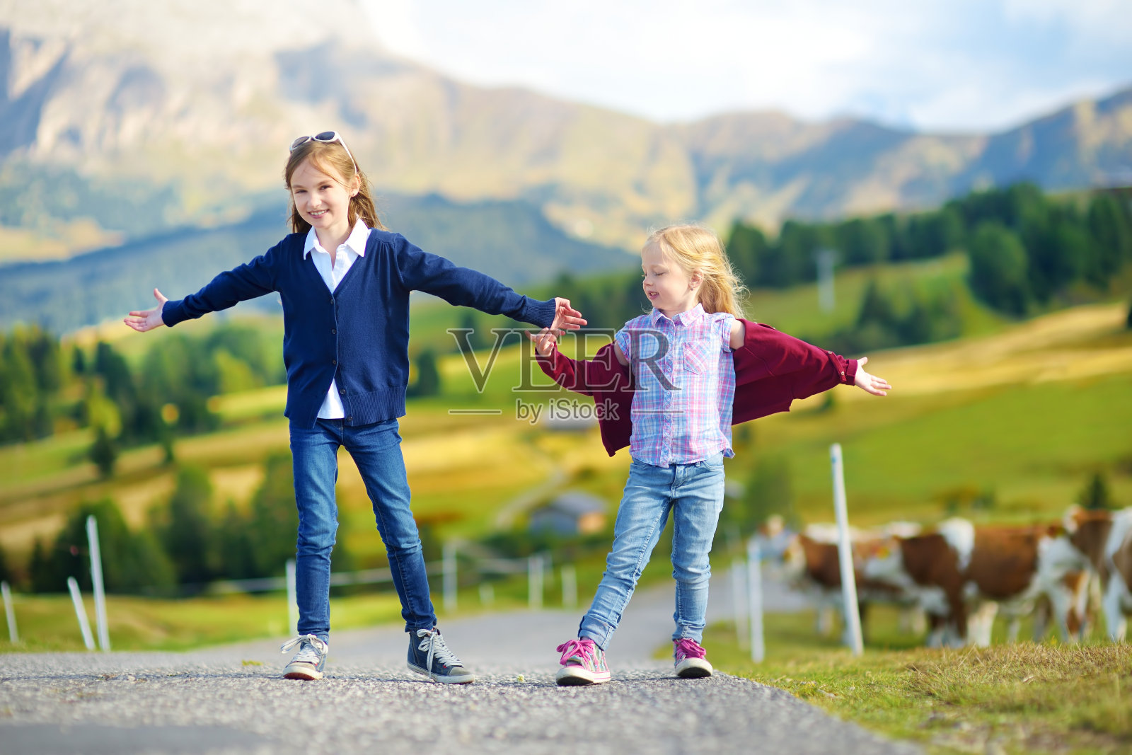 两个可爱的小姐妹在欧洲最大的高海拔高山草甸Seiser Alm徒步旅行照片摄影图片
