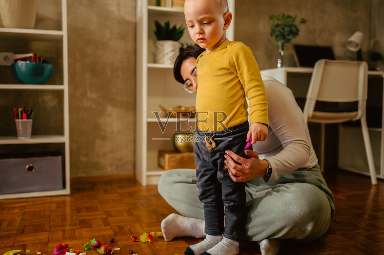 母子俩在家里玩粘土，创作艺术品照片摄影图片