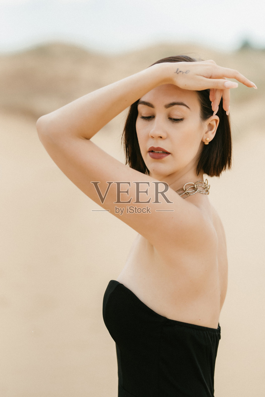 在沙漠里穿着黑色长裙的女孩照片摄影图片