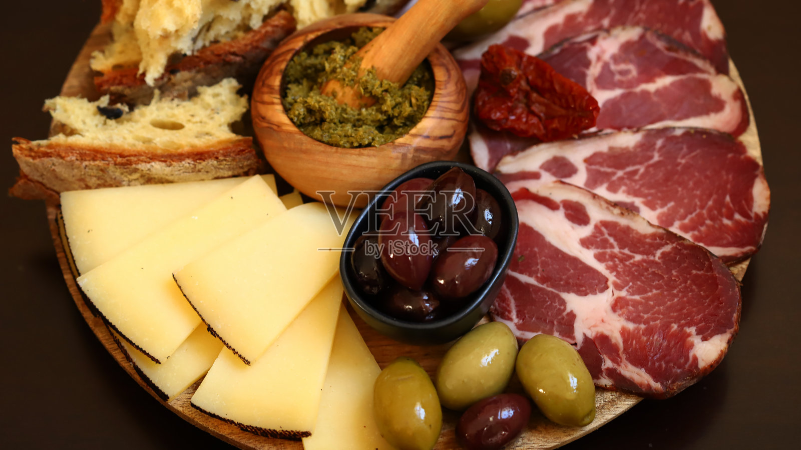 意大利的董事会。奶酪，火腿，橄榄，意大利面包。照片摄影图片