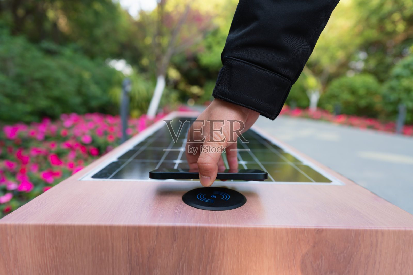 男子使用带有无线充电功能的太阳能座椅照片摄影图片