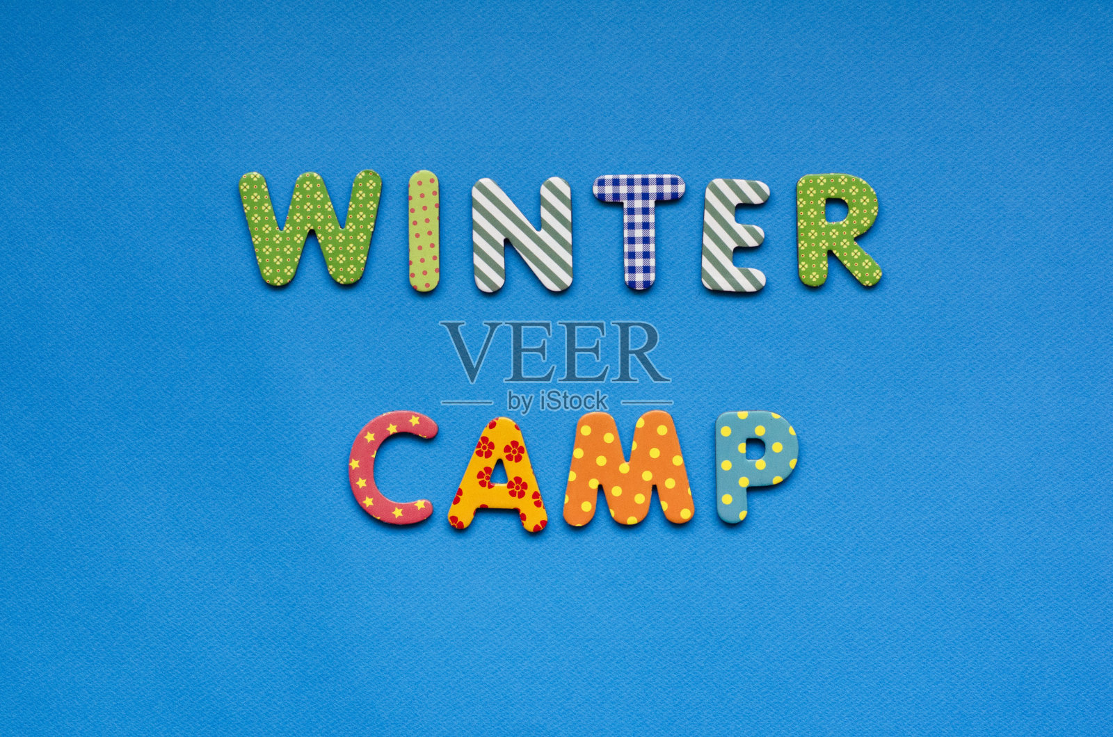 文字冬令营从明亮的彩色纸字母在蓝色纸背景照片摄影图片