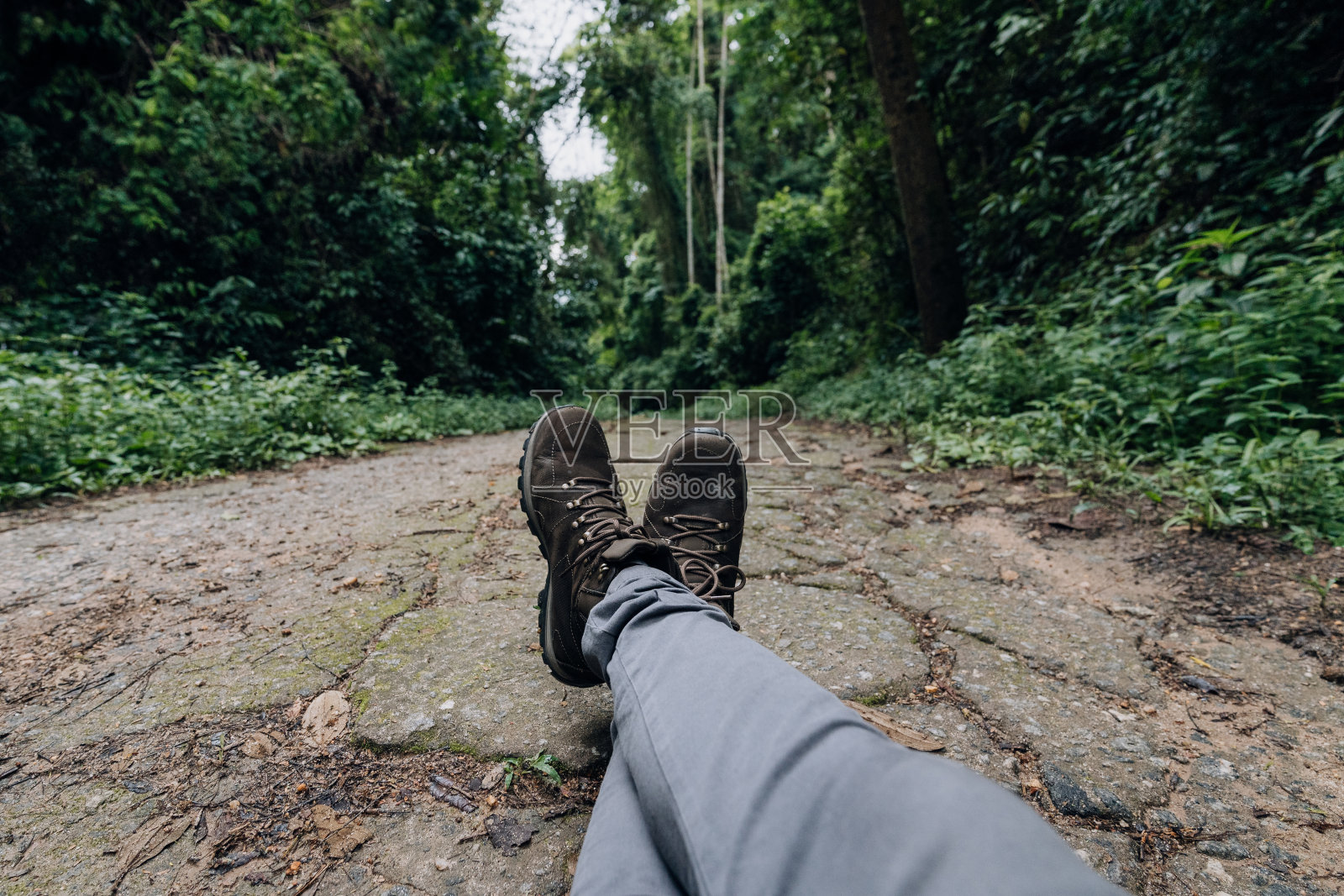 穿着靴子的冒险家在小径上放松照片摄影图片