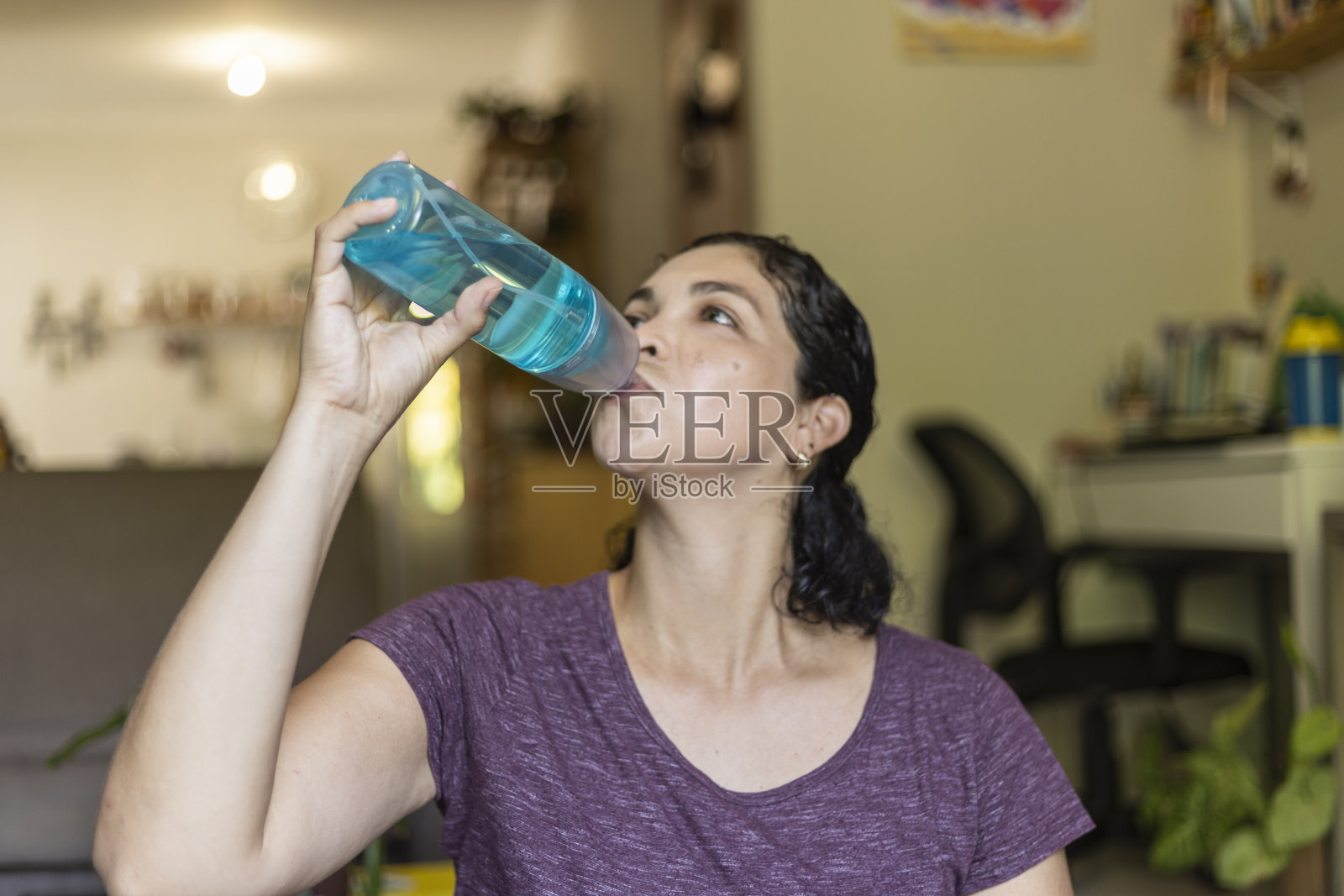 一名拉丁妇女在瑜伽运动后用瓶子喝水照片摄影图片