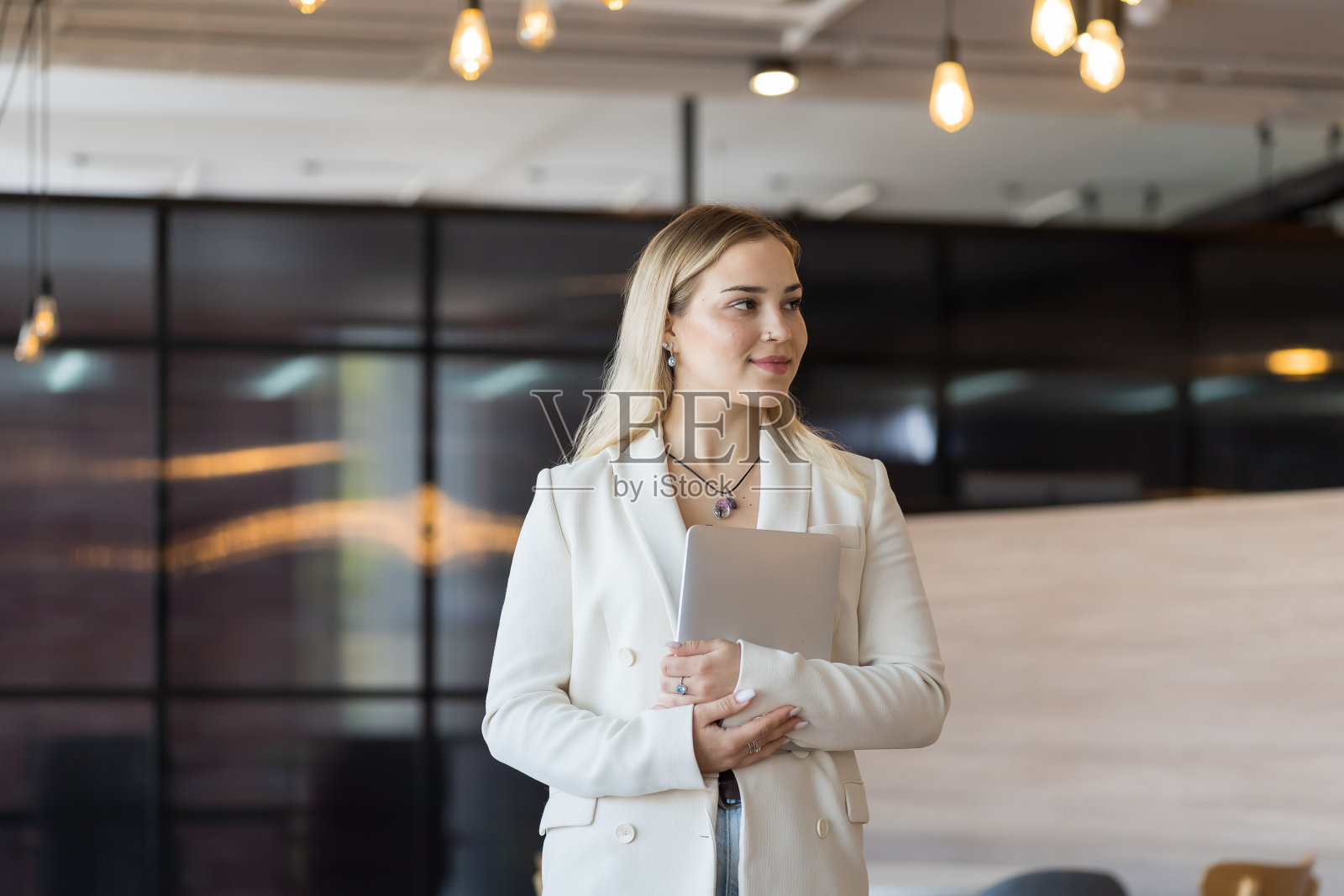 年轻的女商人在办公室用笔记本电脑工作的肖像照片摄影图片