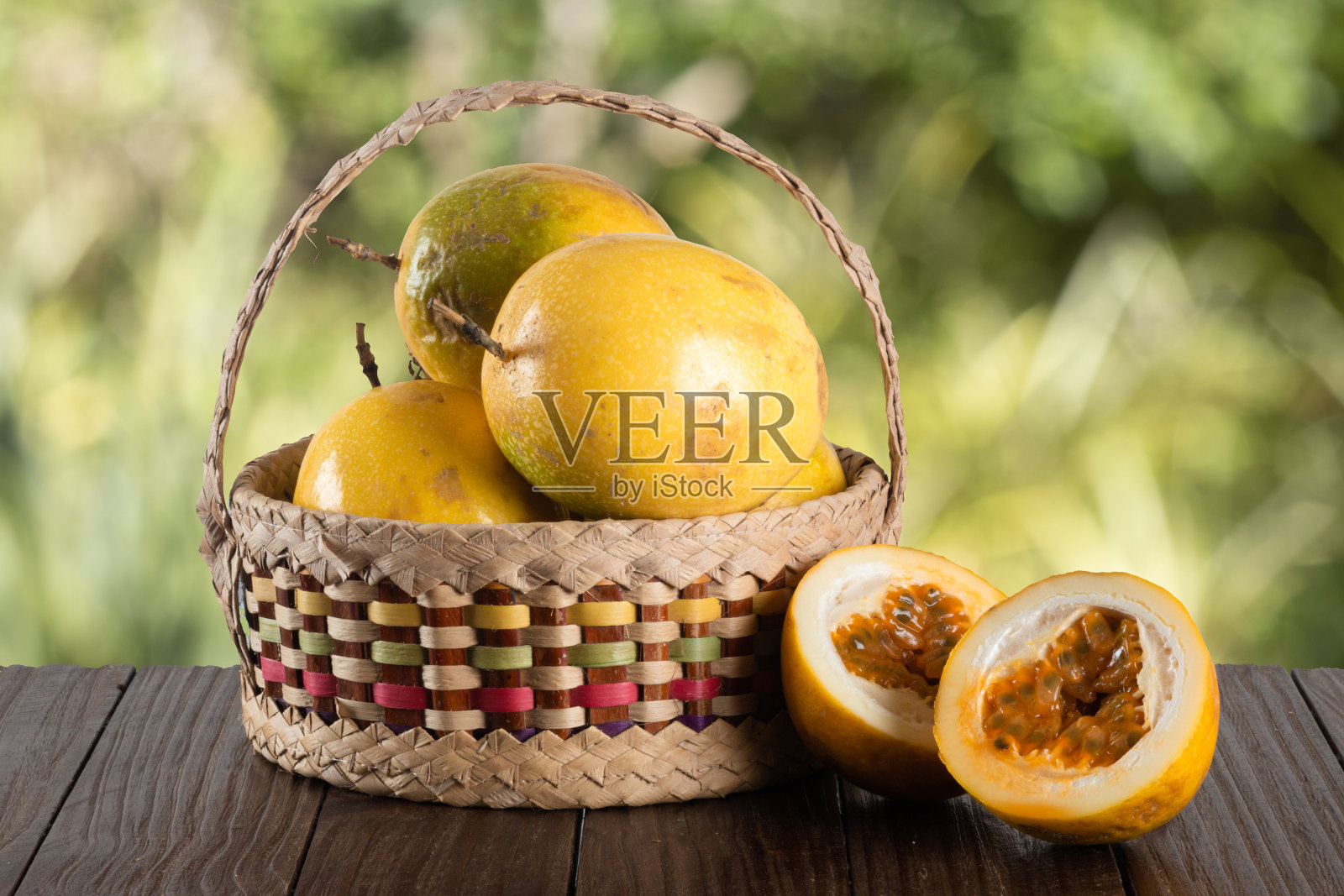 篮子与黄色成熟百香果与模糊的绿色背景照片摄影图片