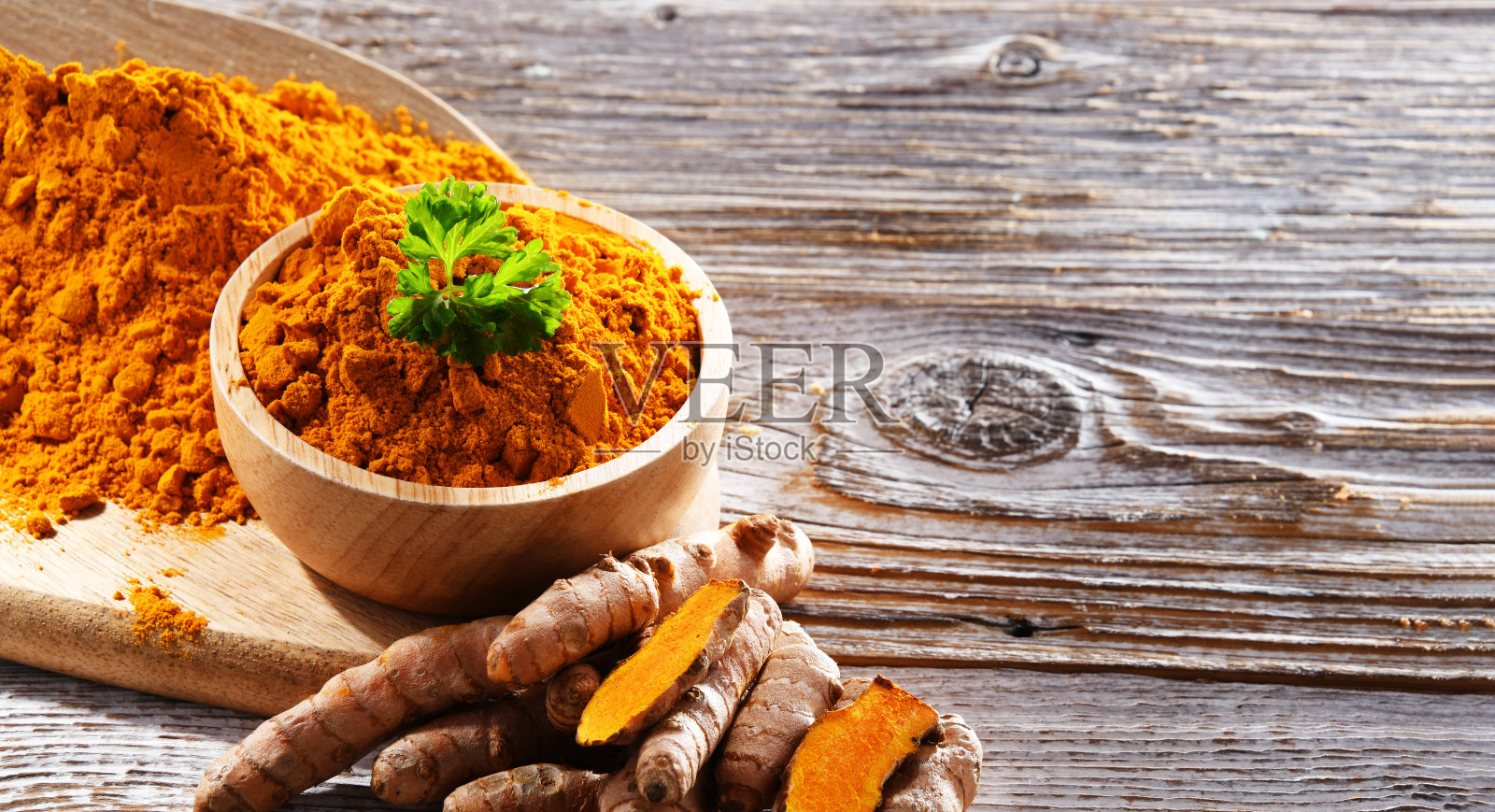一碗磨碎的姜黄及其新鲜根茎照片摄影图片