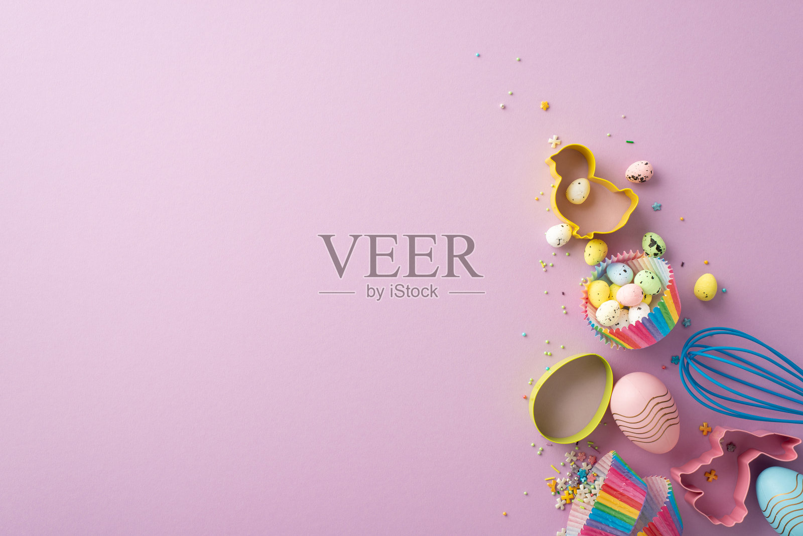 复活节的概念。俯视图照片鸡和兔子形状的烘焙模具搅拌彩色复活节彩蛋和洒在孤立的紫丁香背景与空白照片摄影图片