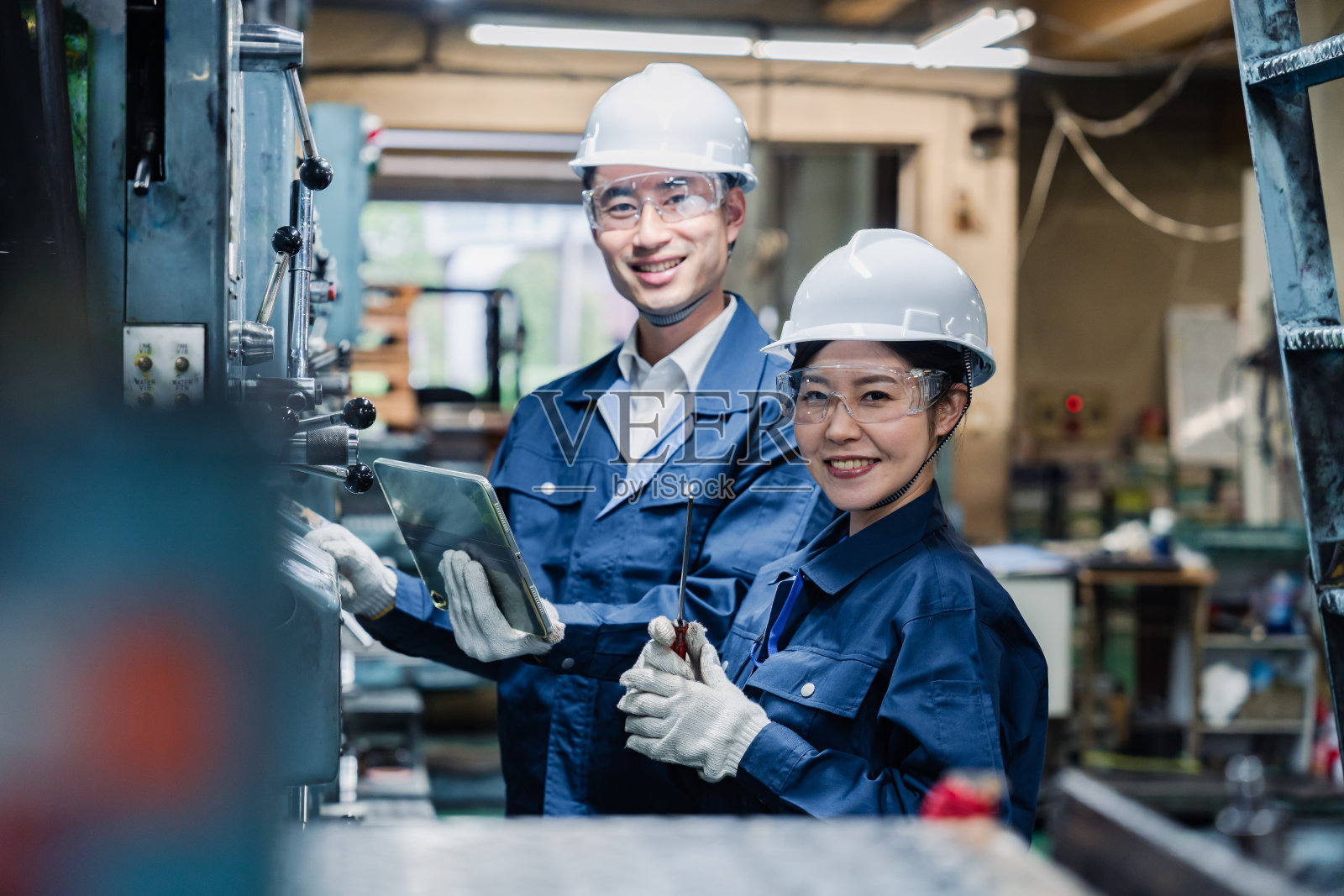 技术人员一边工作一边检查他们的平板设备照片摄影图片