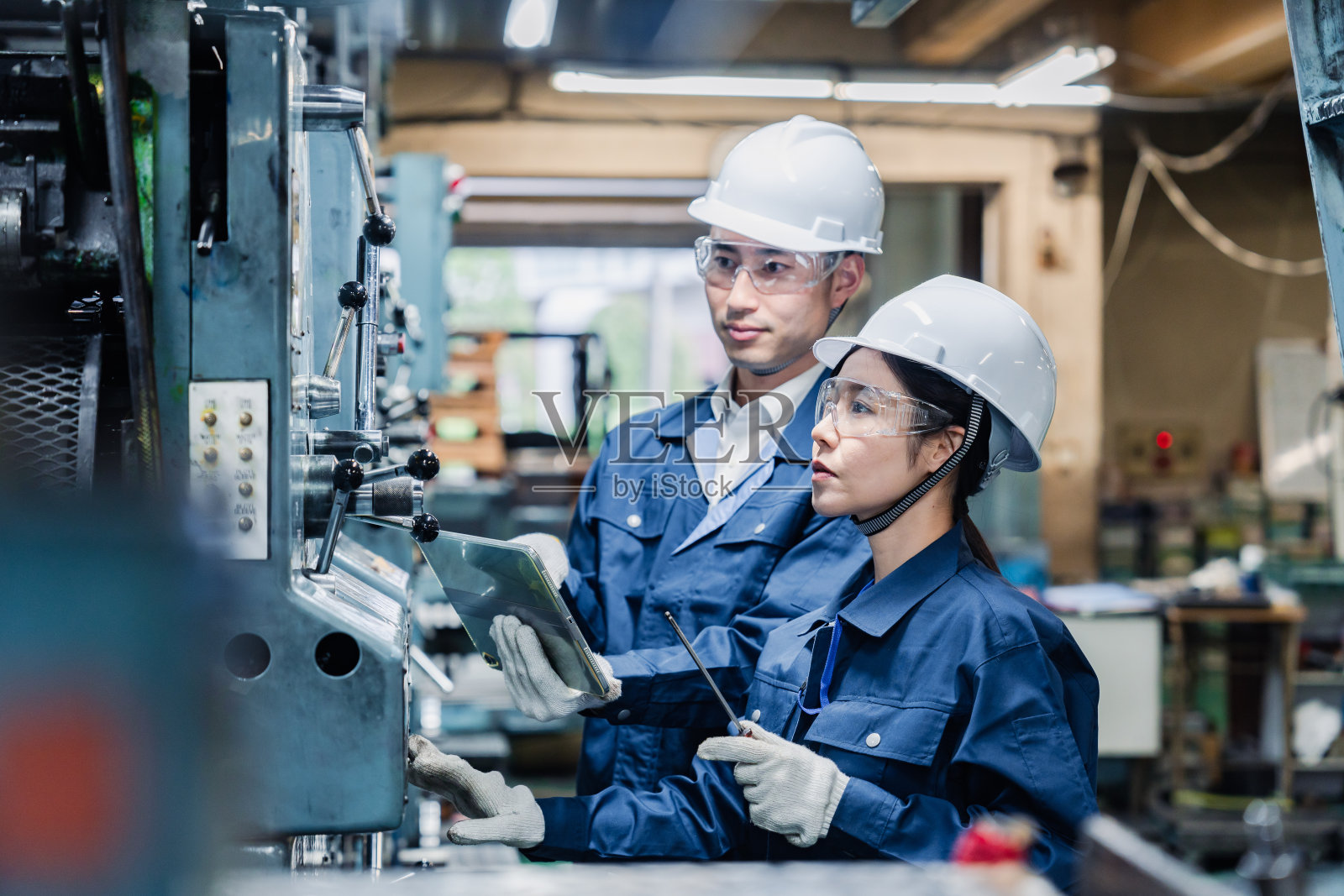 技术人员一边工作一边检查他们的平板设备照片摄影图片