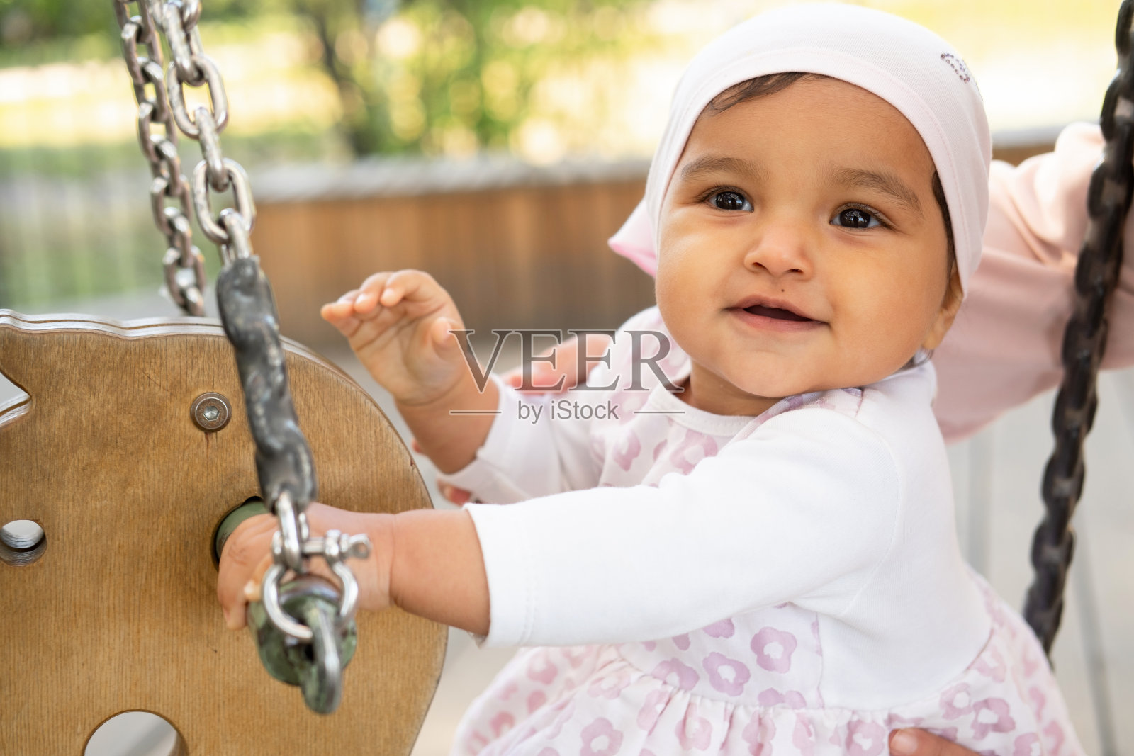 一个夏天，小女孩坐在公园的秋千上，是时候玩游戏了照片摄影图片