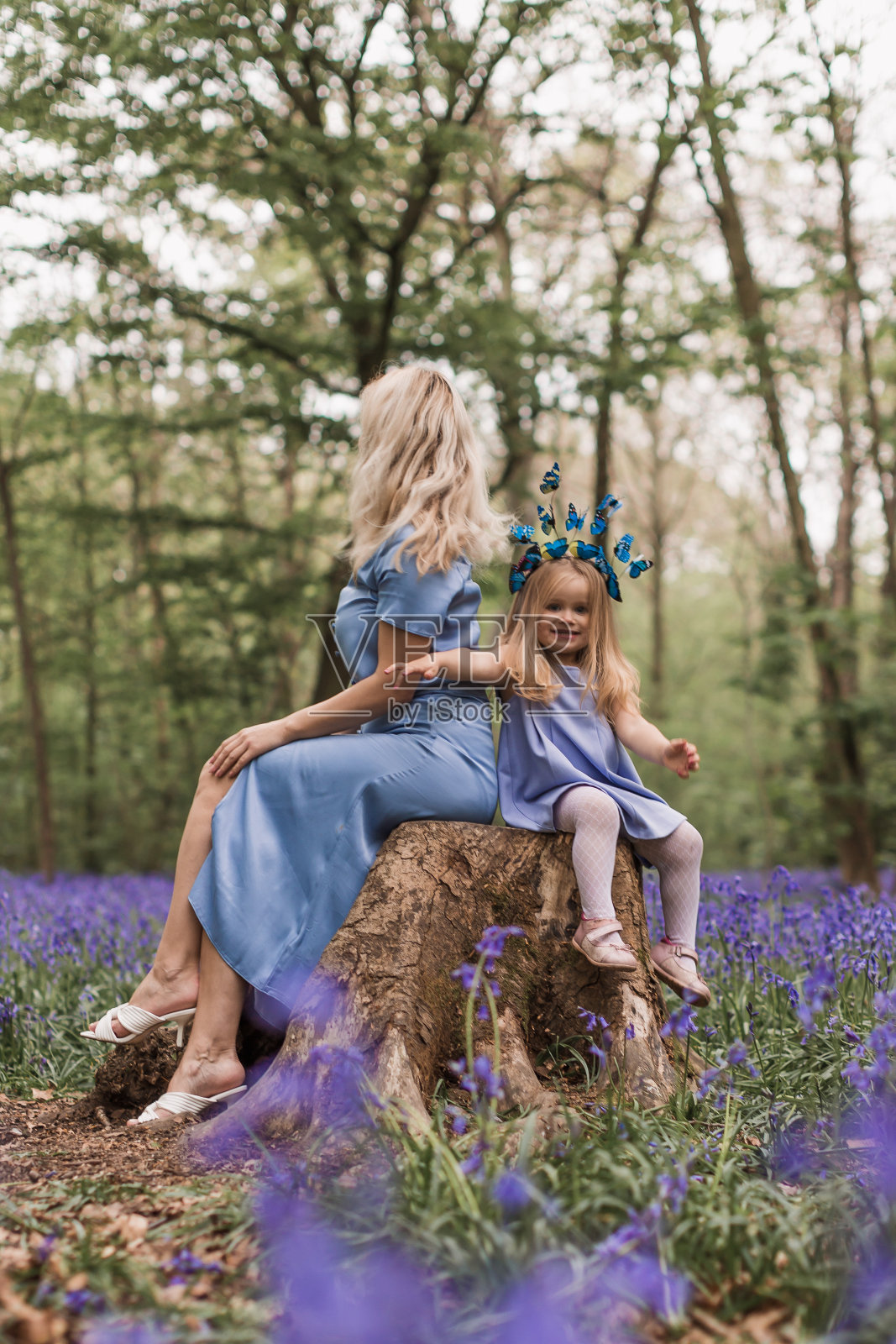 母亲和孩子在户外。幸福的两个家庭，年轻微笑的女人和她可爱的蹒跚学步的女儿在森林里享受美丽的一天，有风信子花照片摄影图片