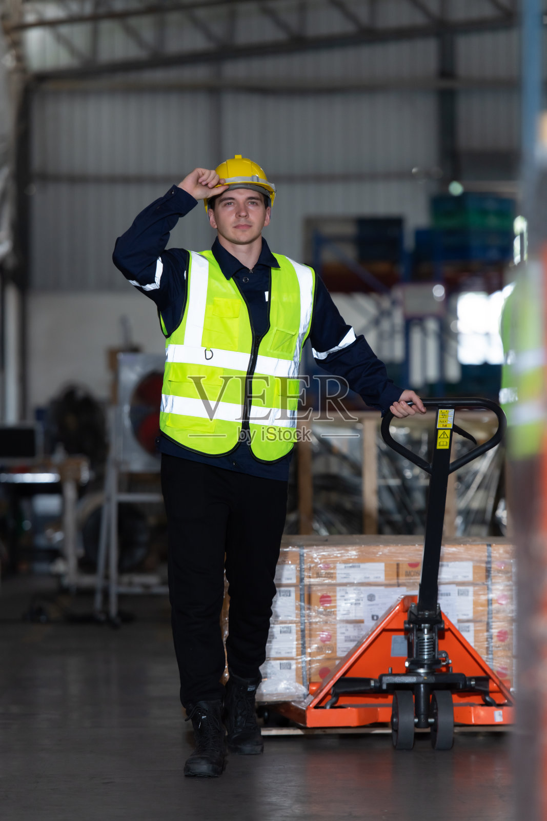 汽车配件库的工人用手推车将汽车配件箱搬运到仓库的仓储货架上，等待运送到汽车装配线照片摄影图片