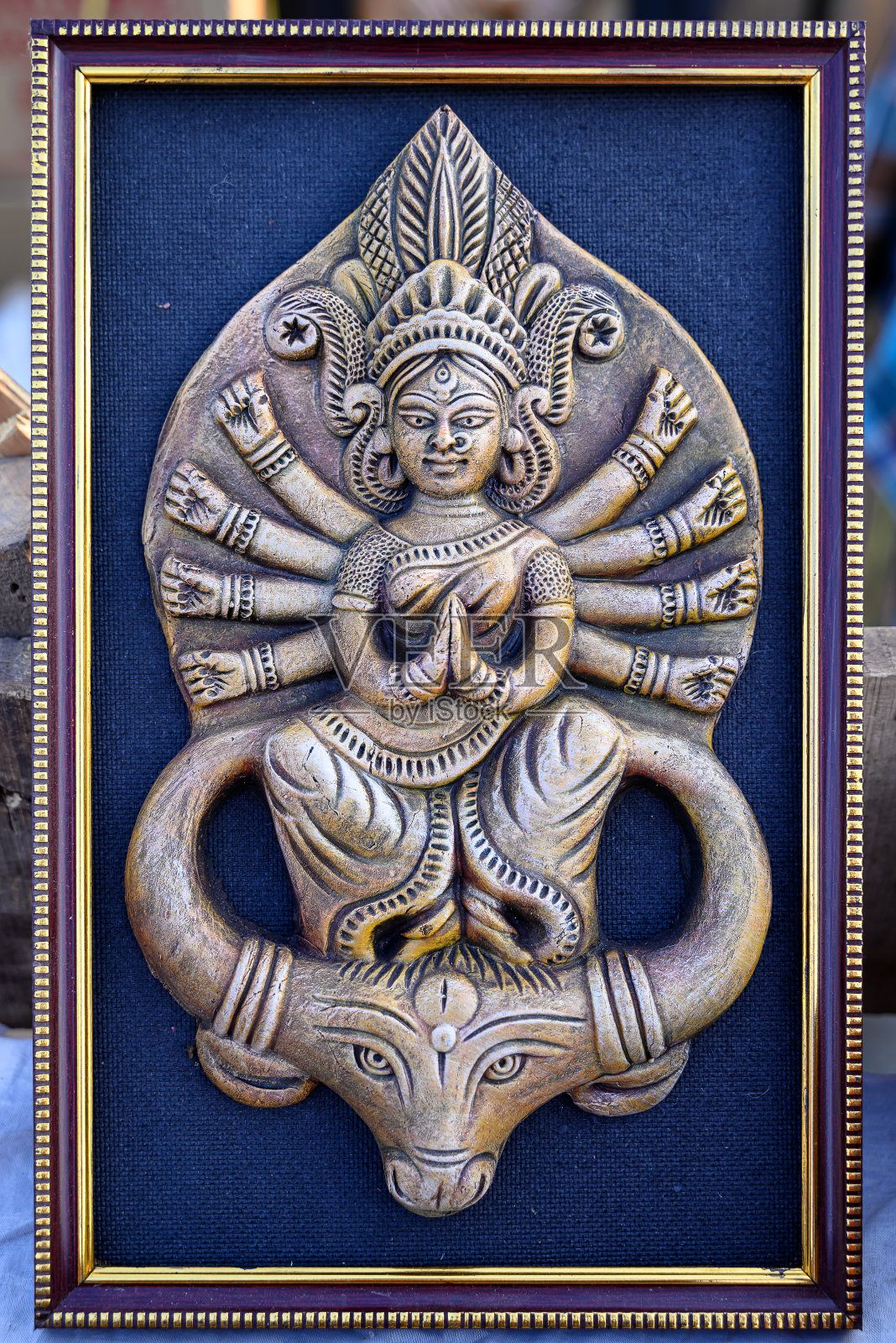 美丽的手工雕刻的女神杜尔迦展示在一个商店出售模糊的背景。印度艺术和手工艺品。照片摄影图片