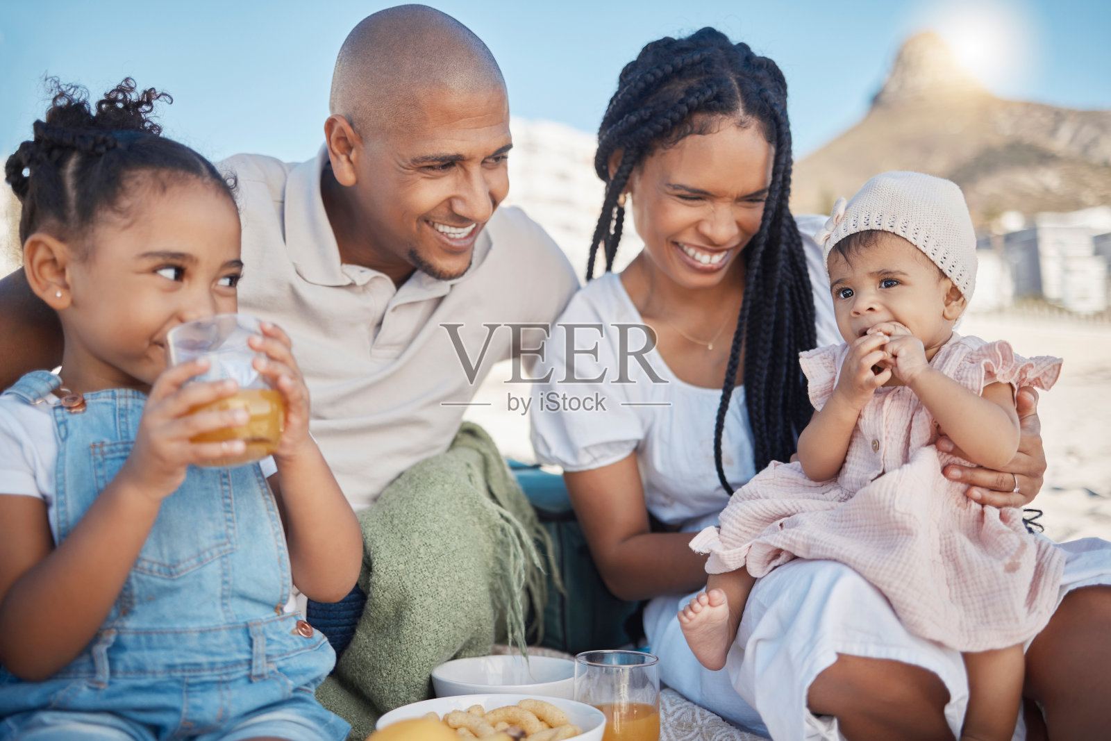 黑人家庭，海滩野餐和度假时的爱，吃着食物，喝着饮料，与母亲，父亲和孩子们一起快乐。婴儿与男人，女人和兄弟姐妹在户外大自然暑假照片摄影图片
