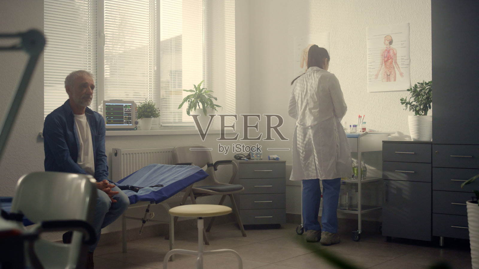 女治疗师检查老年病人的喉咙。老人在诊所看医生。照片摄影图片