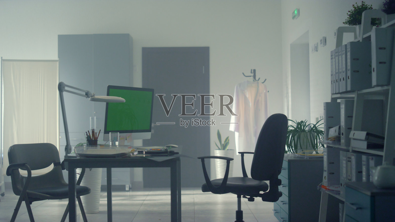 医生办公室绿屏现代化电脑。医生利用科技工作。照片摄影图片