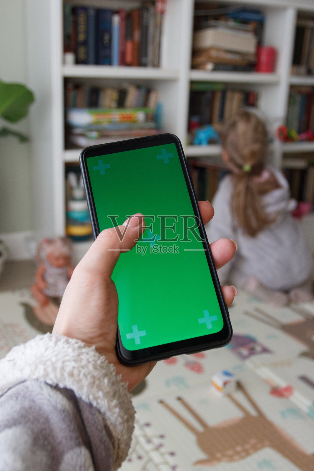 绿色屏幕的智能手机。女子手里拿着智能手机照片摄影图片