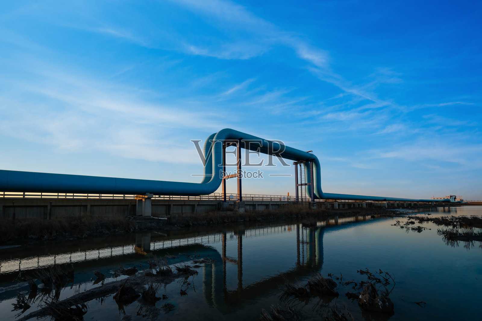 蓝色的管道在夕阳下驶向炼油厂照片摄影图片