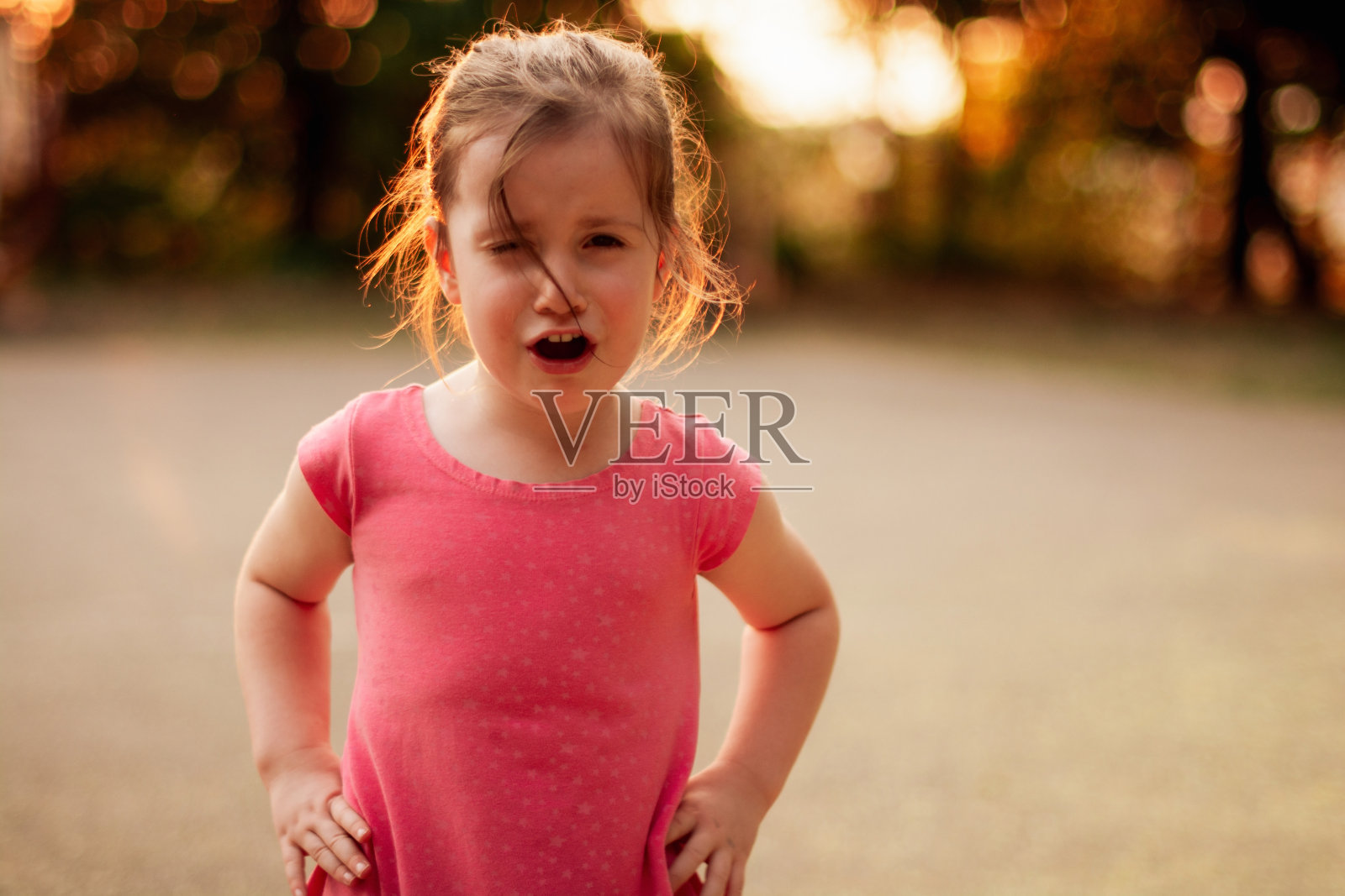 小女孩站在公园里哭着看着镜头照片摄影图片