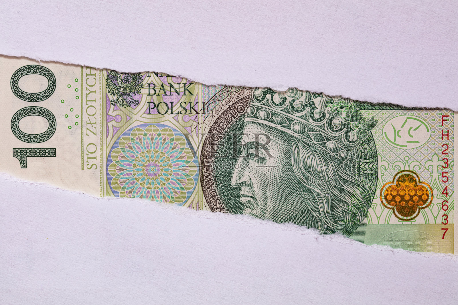 在撕破的纸洞里擦亮100 Zotych钞票照片摄影图片