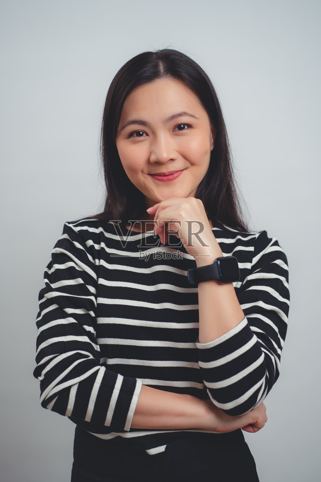 亚洲女人快乐地微笑着站在白色背景上。照片摄影图片